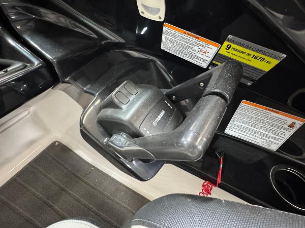 Throttle control of a 2014 Yamaha Boats 212X, featuring capacity and safety labels.