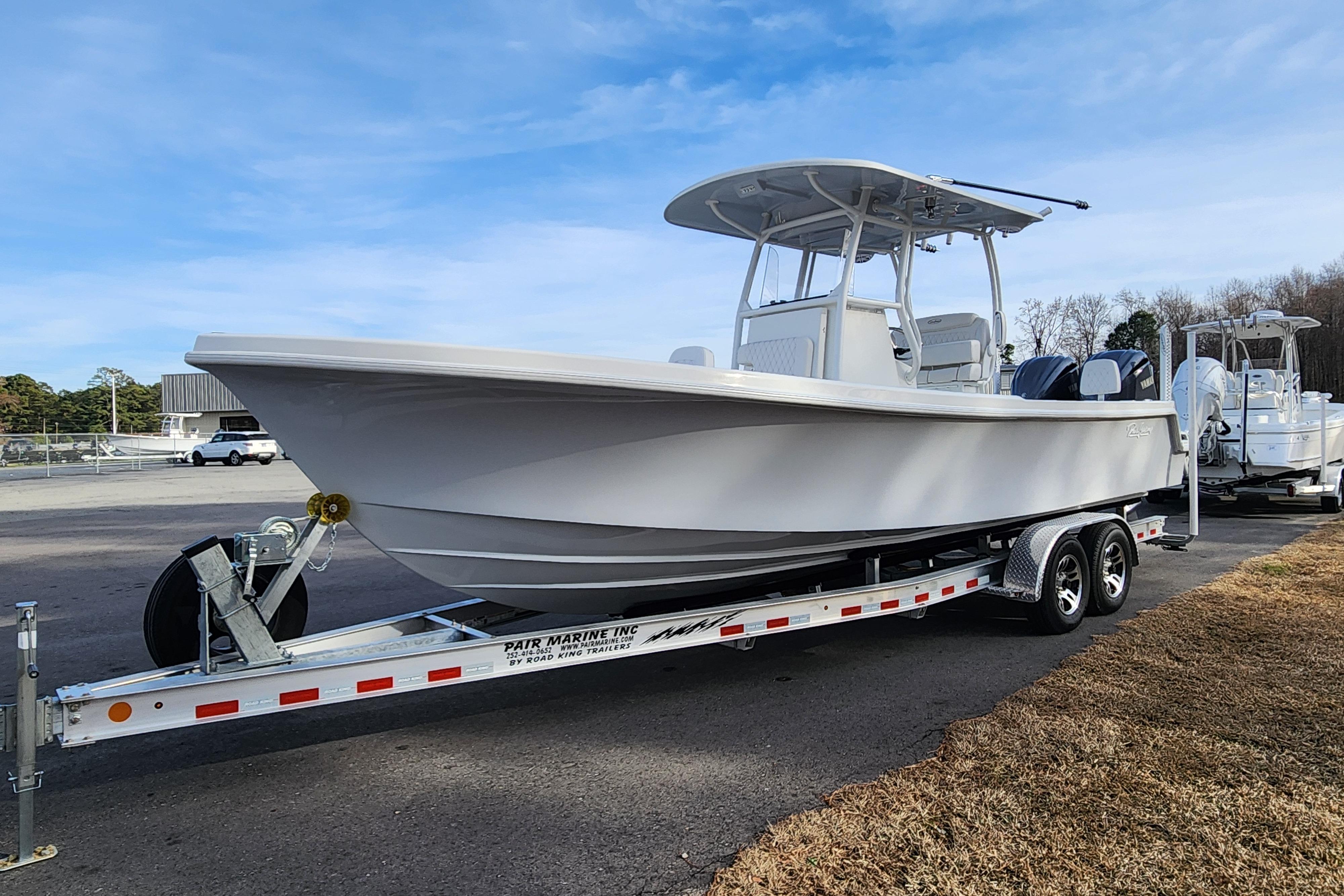 2024 Pair Customs 27 CC boat on trailer, parked outdoors under clear sky.