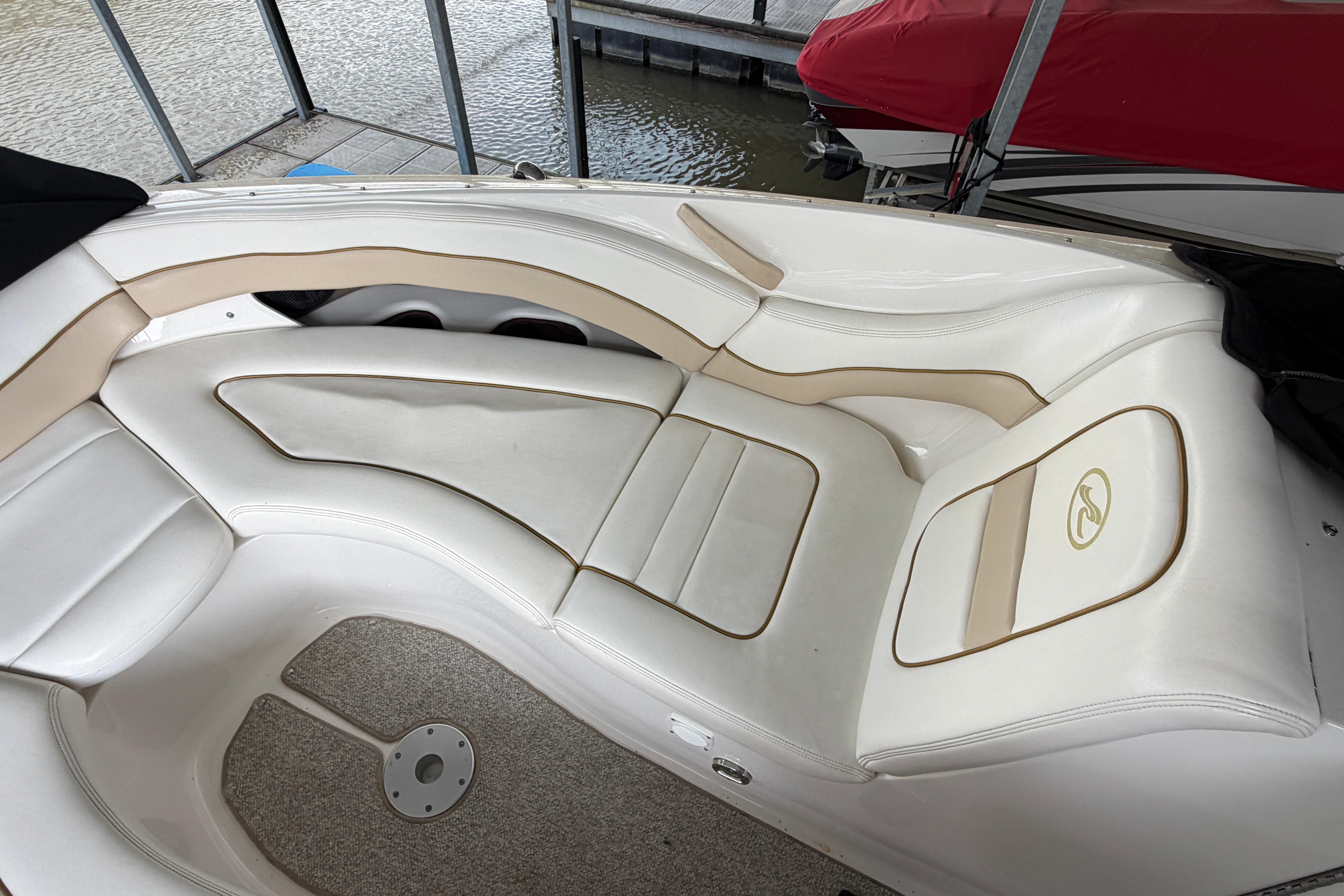 2003 Sea Ray 290 Bowrider interior with white and beige seating, docked by water.
