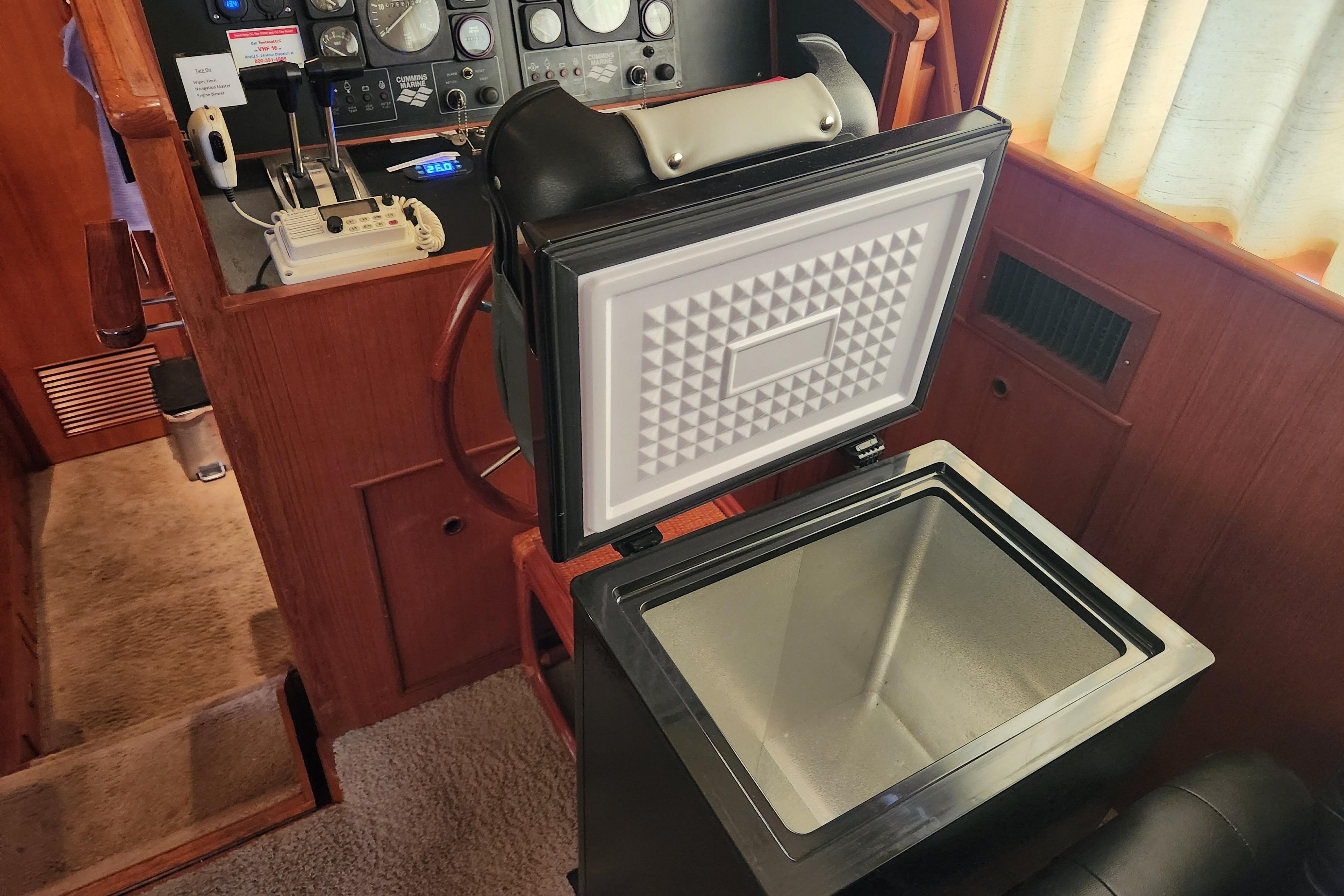 Interior of 1989 Hyatt Double Cabin Motoryacht with open cooler and control panel.