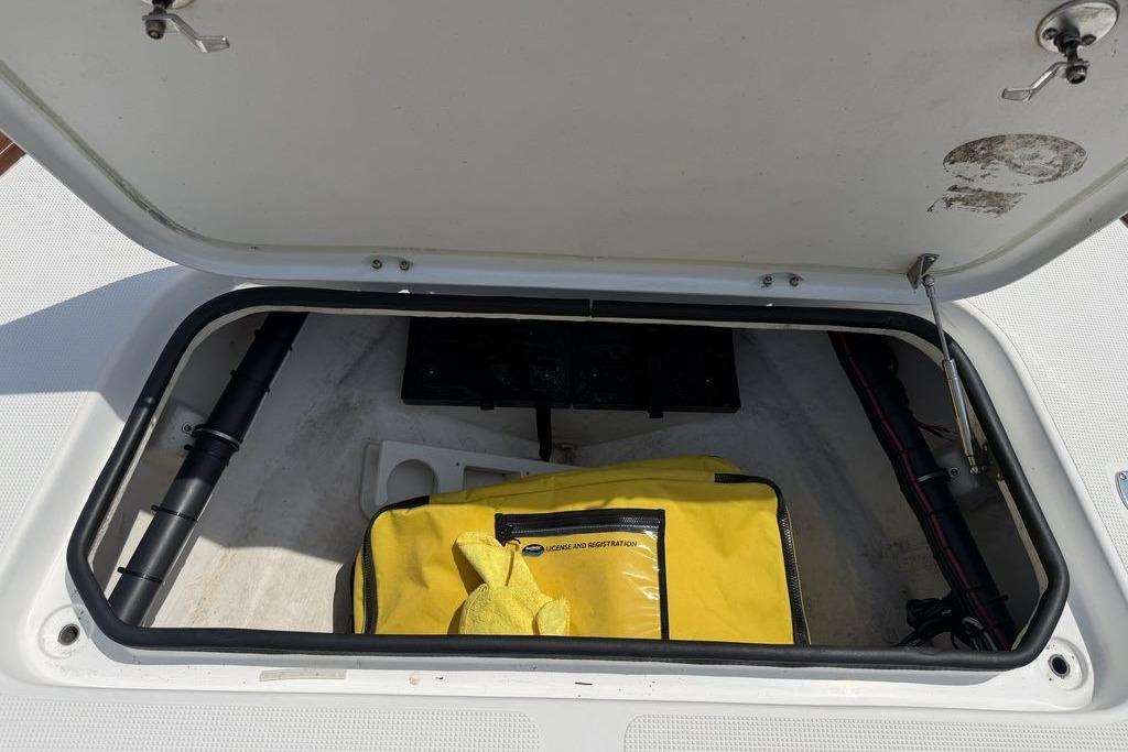 Open storage compartment in a 2012 Chaos 16 Bonefish boat with yellow bag inside.