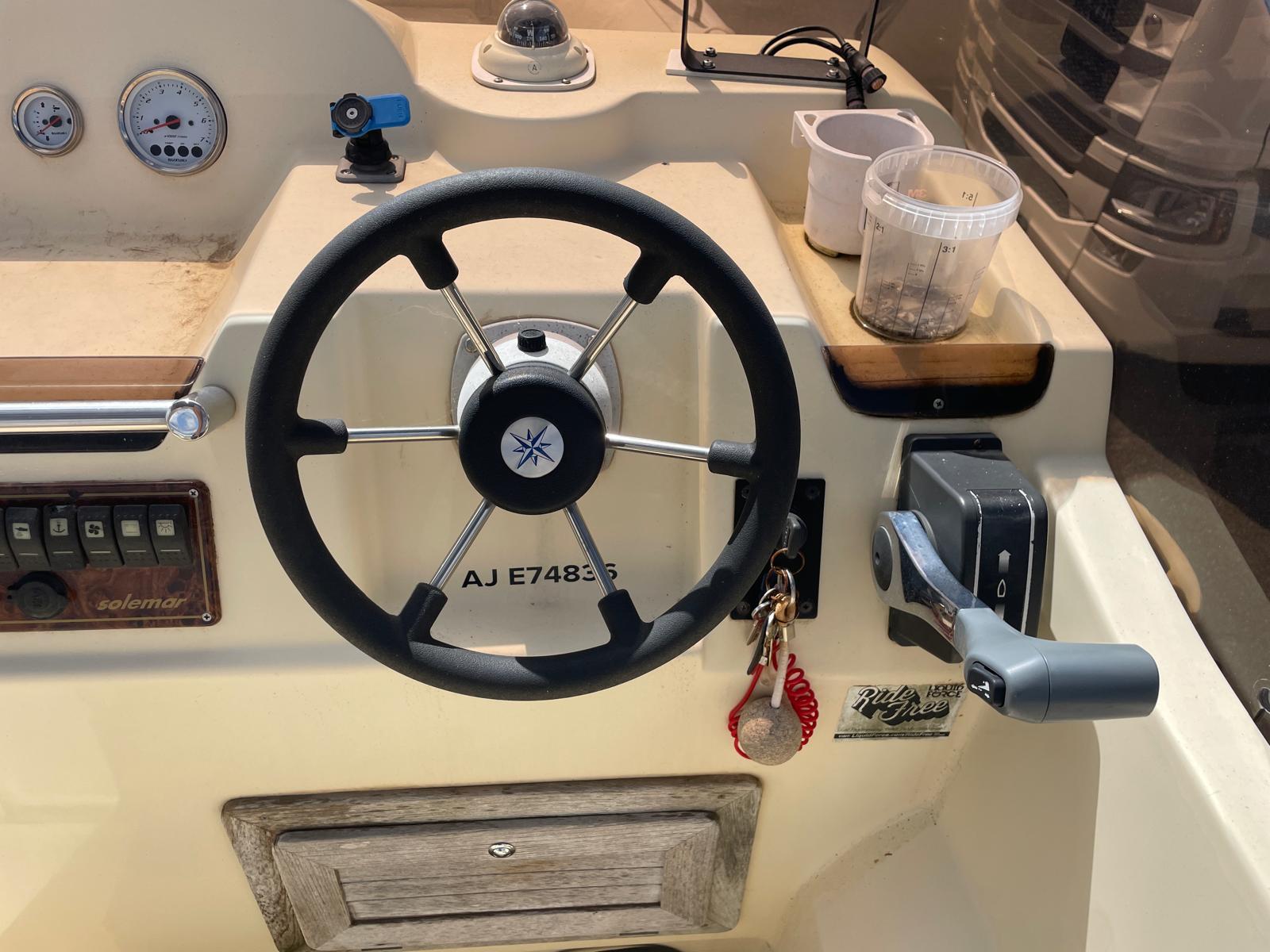 Steering wheel and controls of a 2012 Solemar 23 boat cockpit.