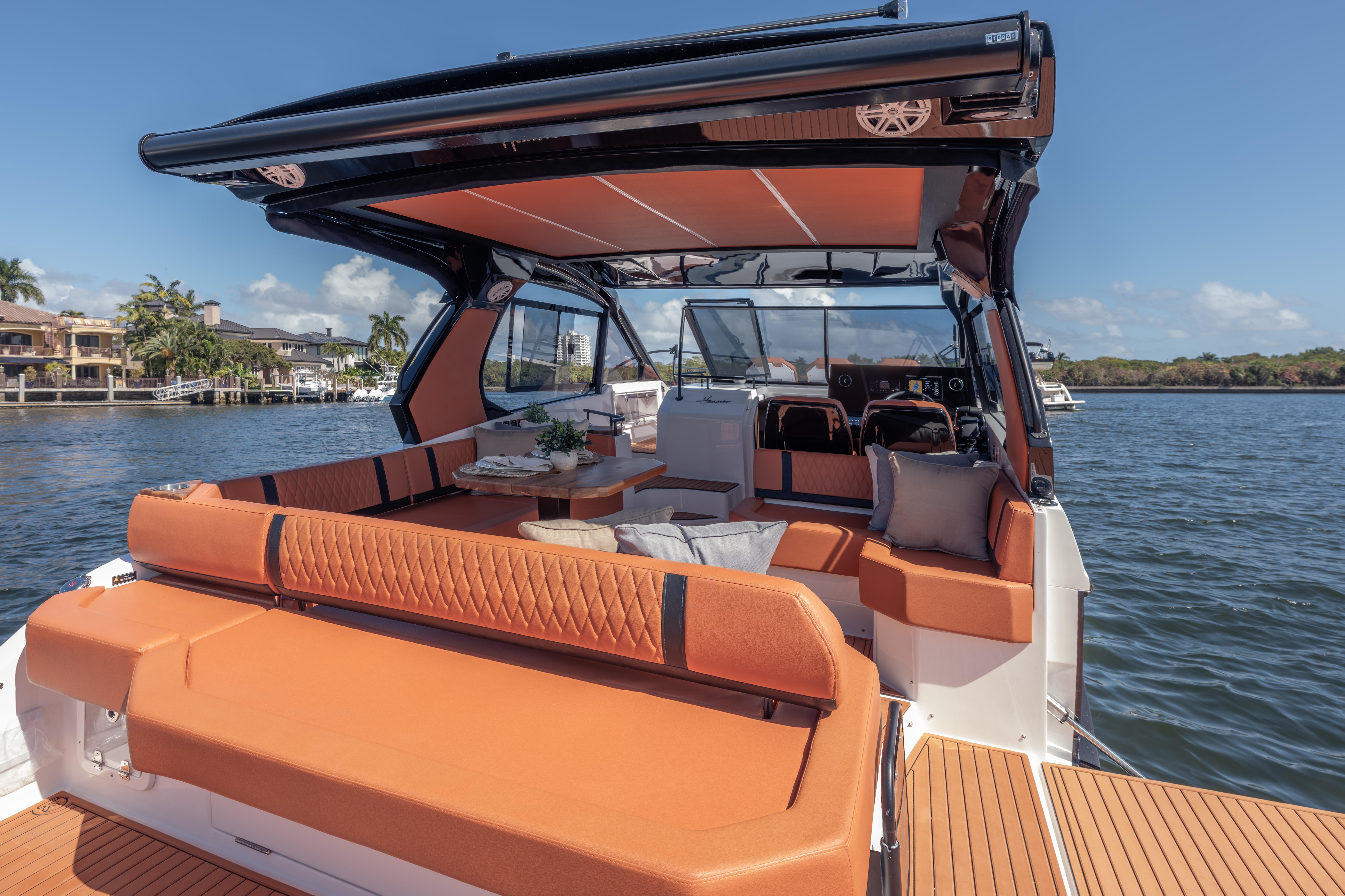Luxurious 2026 Hanover 387 yacht interior with orange seating, cruising on a sunny day.