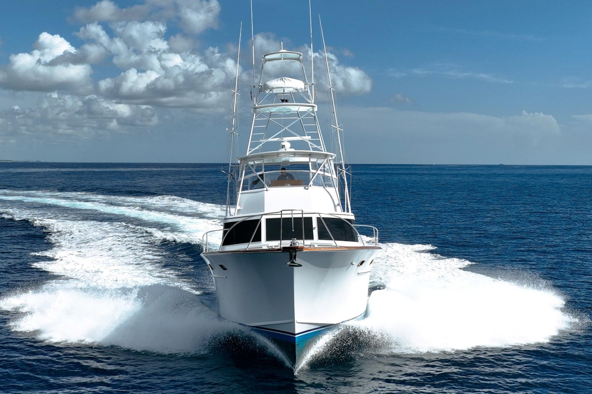 1983 Rybovich 55 Convertible yacht cruising on open ocean under blue sky.
