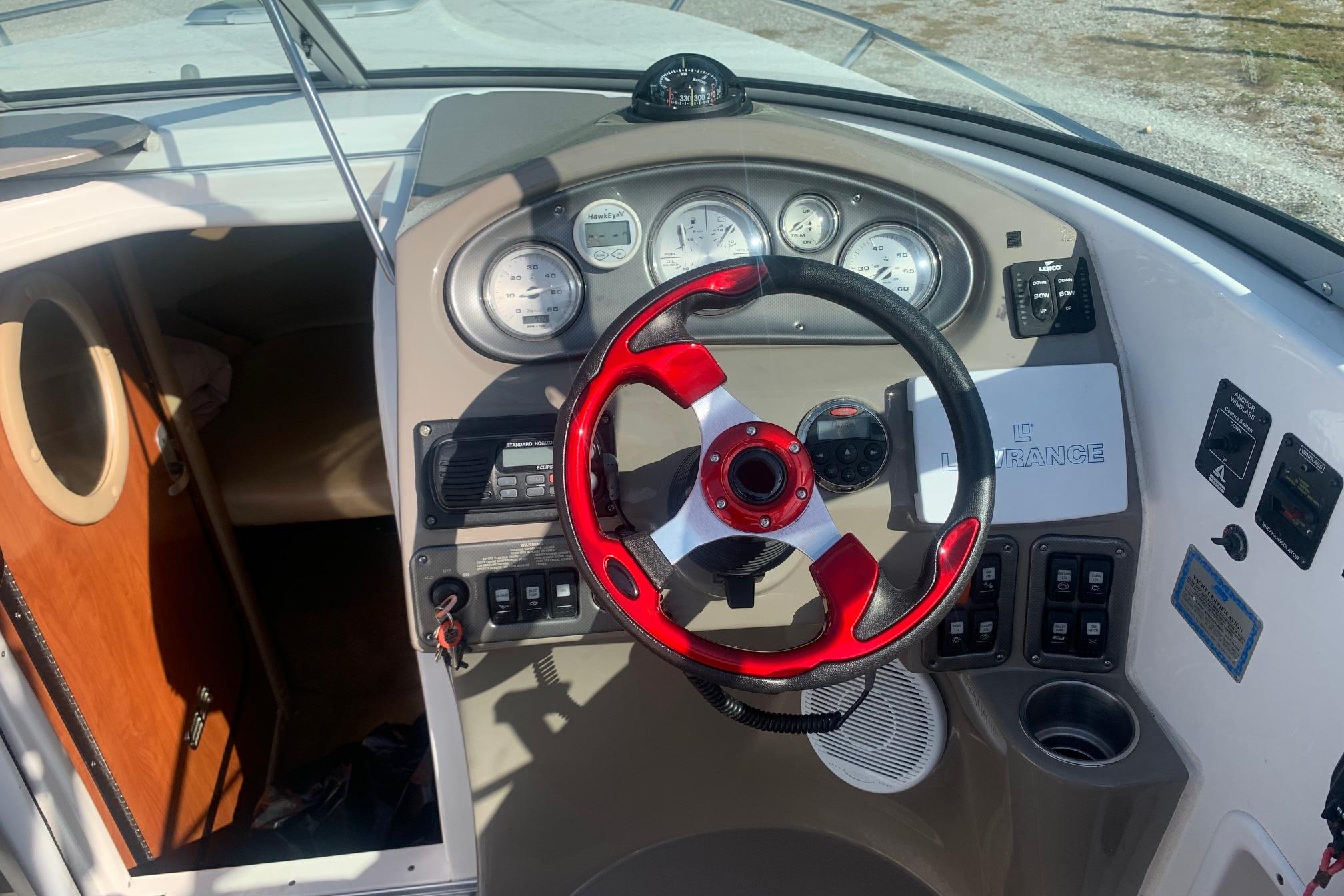 2006 Rinker 282 Captiva Cuddy boat dashboard with red steering wheel and instrument panel.