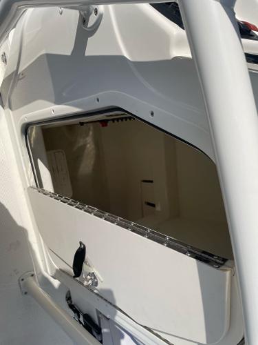 2024 Mako 214 CC boat storage compartment with open hatch.