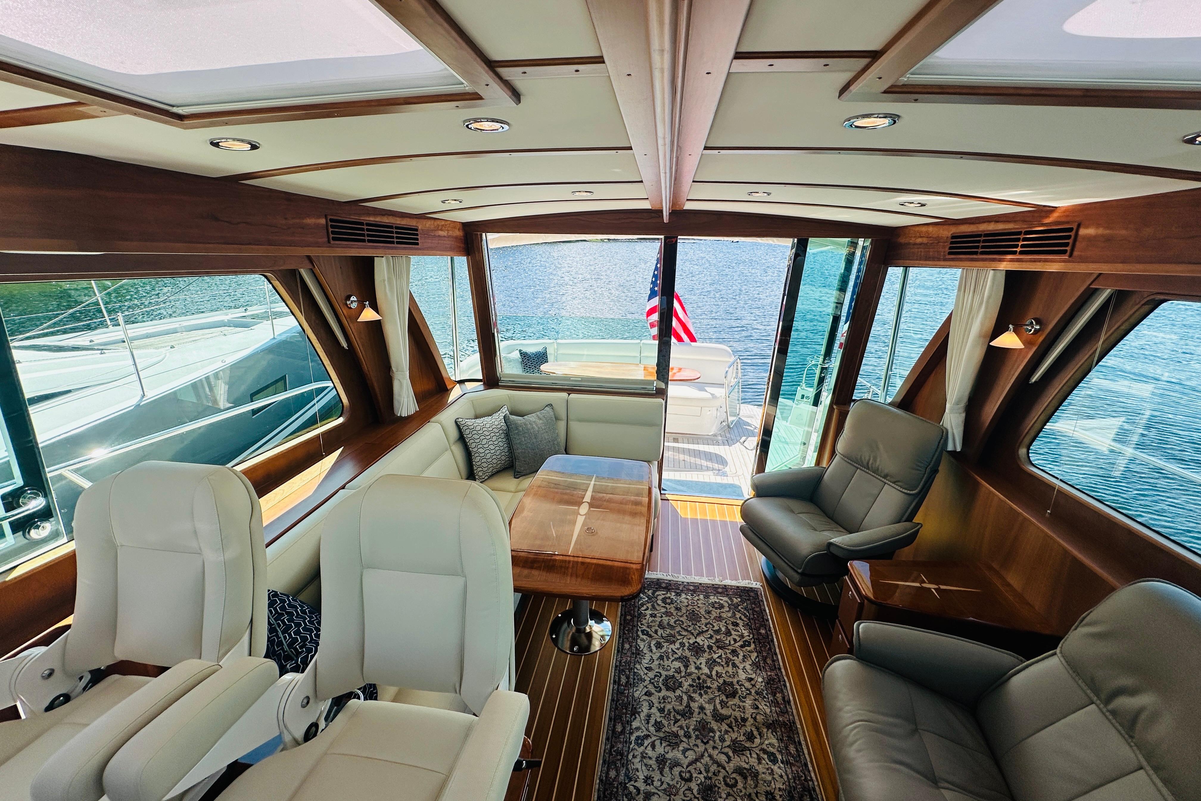 Luxurious interior of 2025 Sabre 48 Salon Express yacht with elegant seating and panoramic windows.