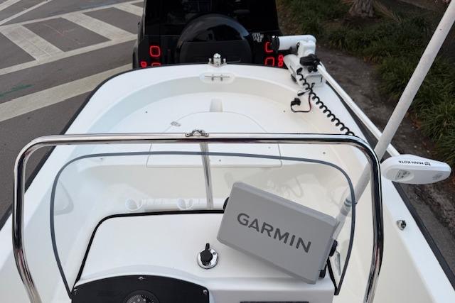 2016 Boston Whaler 150 Montauk boat with Garmin navigation system, docked near a road.