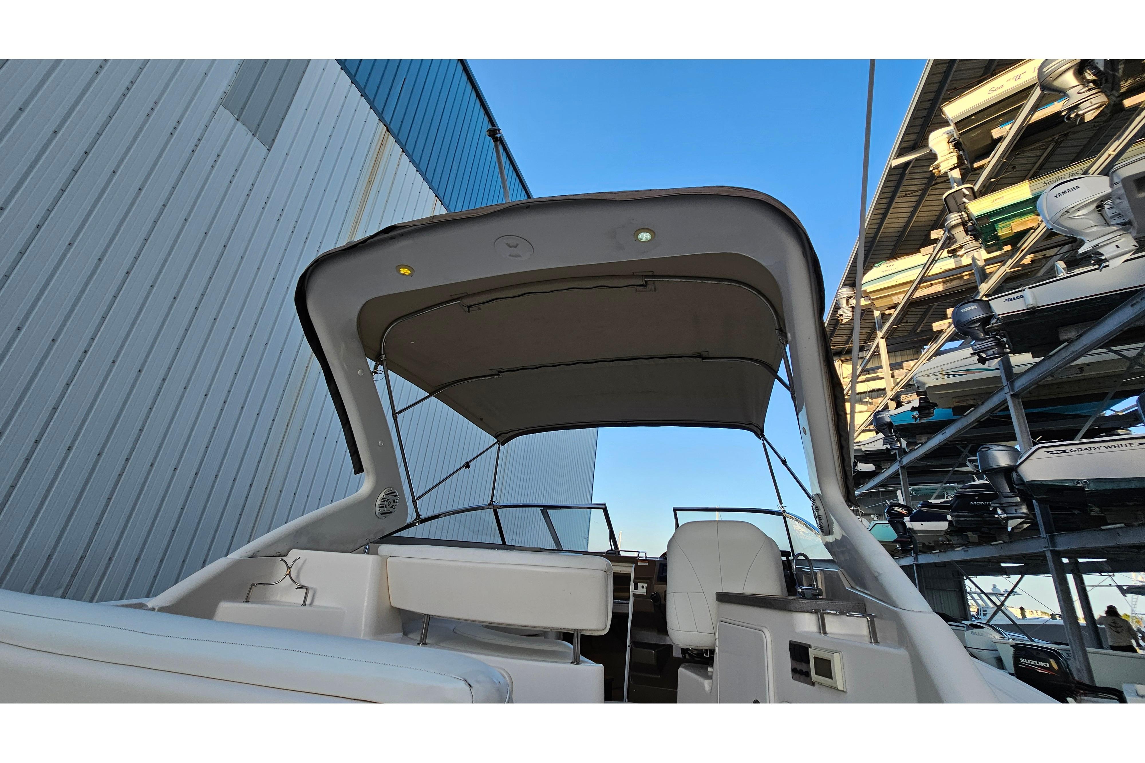 2005 Regal 3060 Window Express boat with canopy, docked near storage facility.