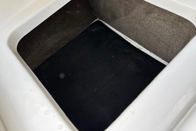 Storage compartment of a 2017 Searay SPX210 boat, featuring a black mat interior.