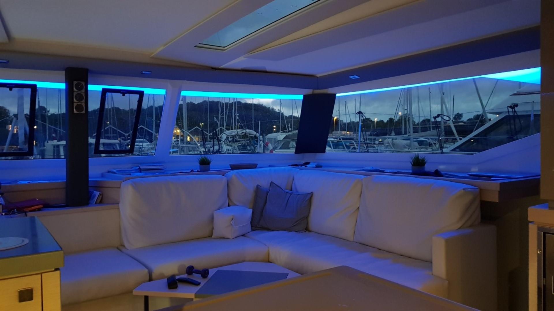 Luxurious interior of 2019 Fountaine Pajot Saona 47 yacht with ambient blue lighting.