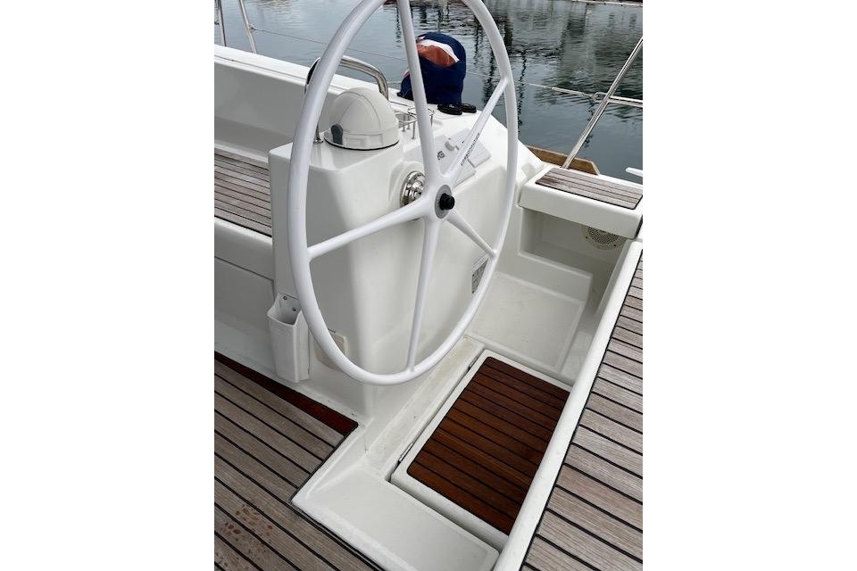 Steering wheel of 2018 Beneteau Oceanis 45 yacht with wooden deck details.