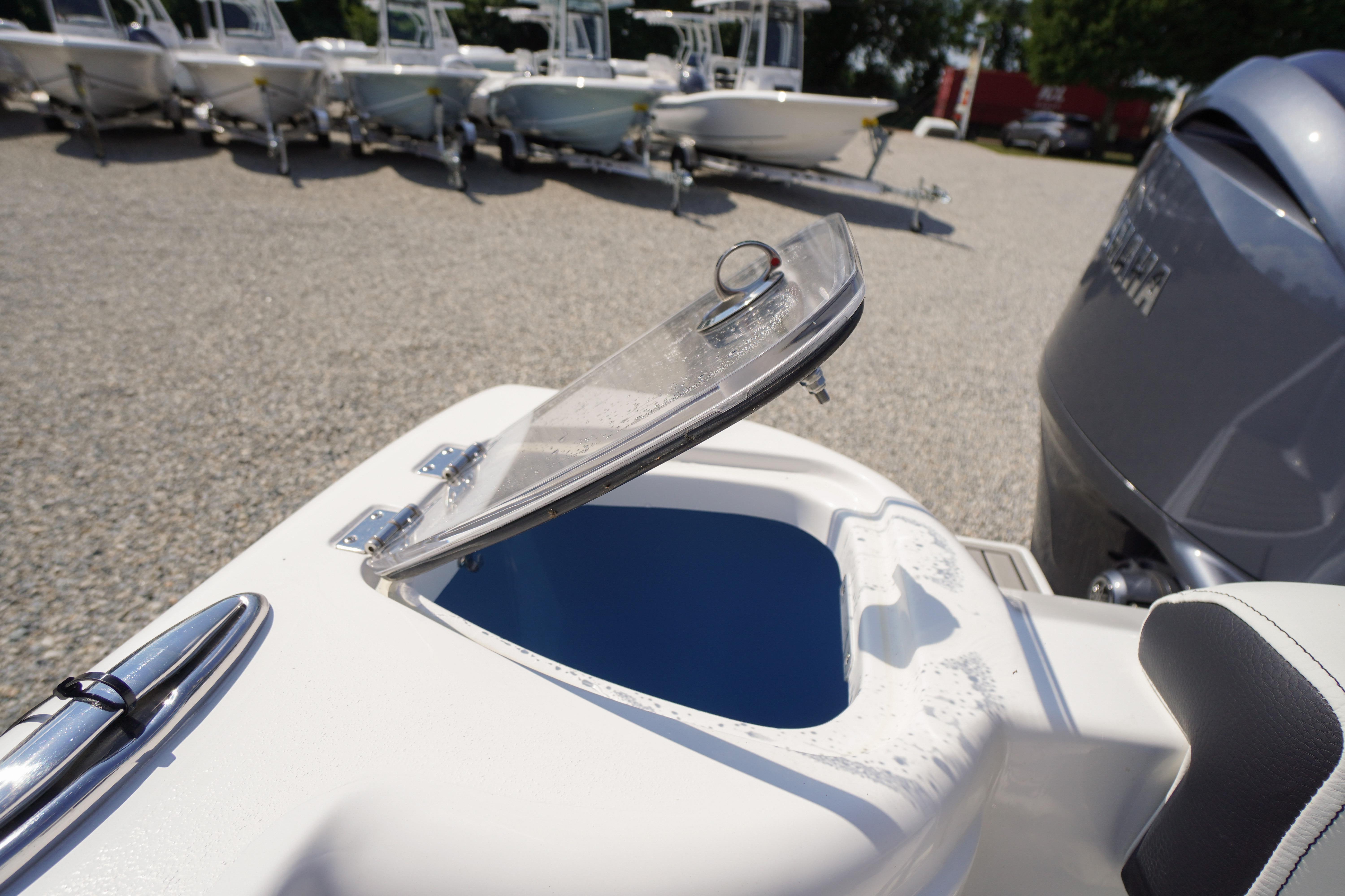 Open hatch on 2026 Tidewater 220 CC Adventure boat, showcasing storage compartment.