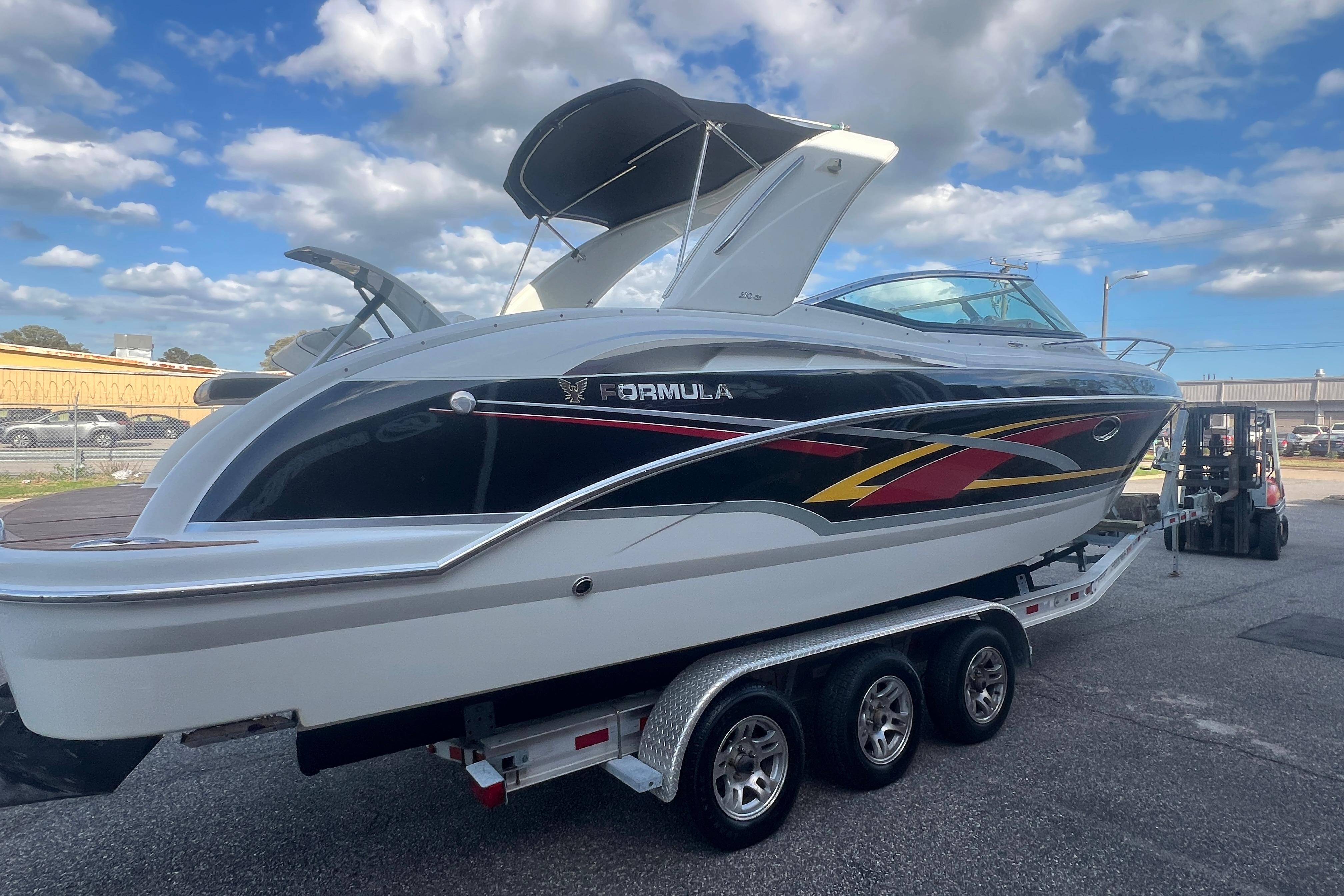 2008 Formula 310 Sun Sport boat on trailer under blue sky.