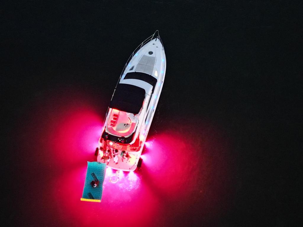 Aerial view of 2006 Fairline 50 yacht with vibrant pink underwater lights.