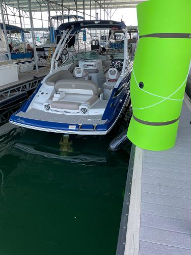 2019 Crownline E255 boat docked in marina with bright green buoy.