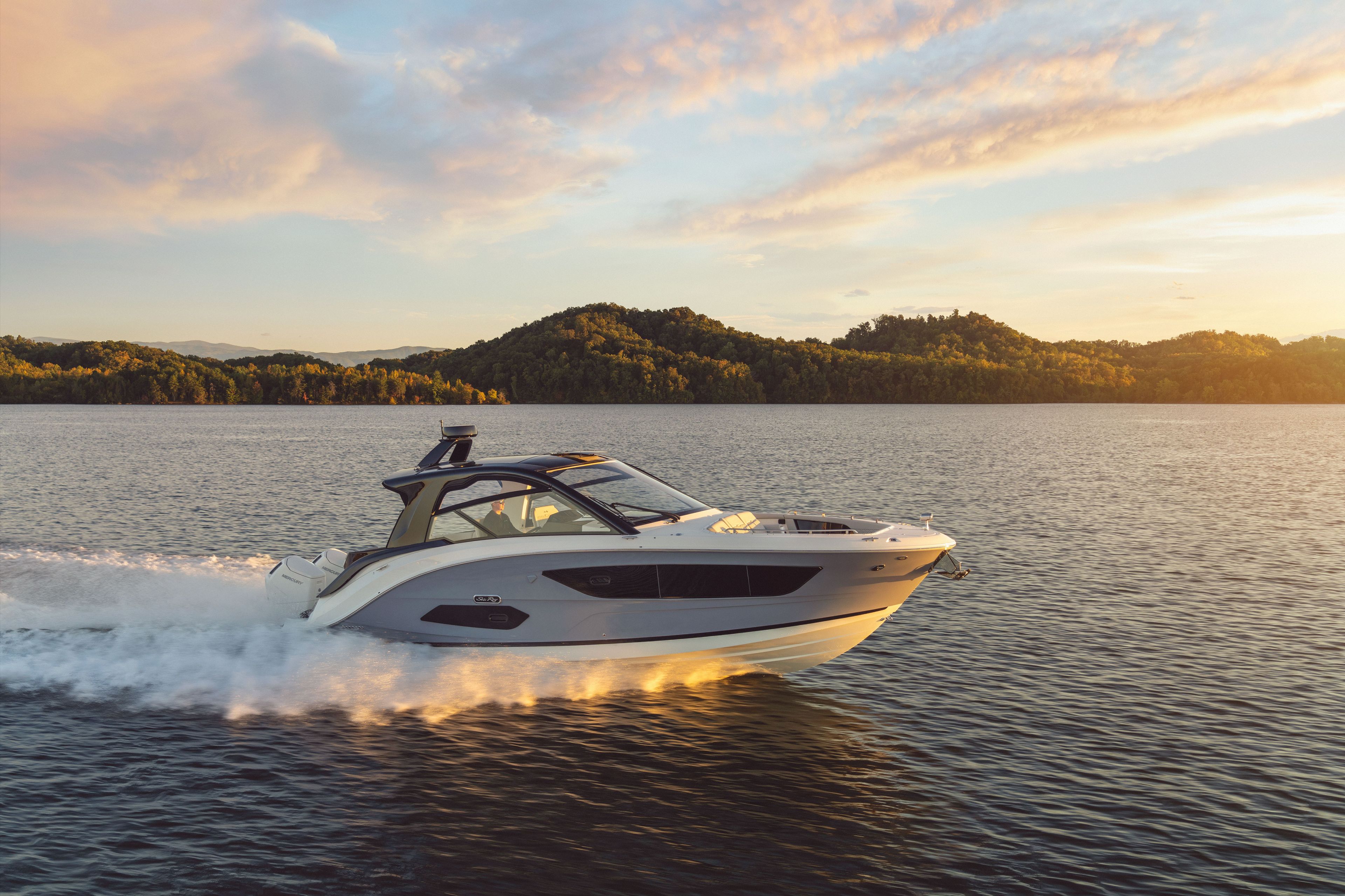 2026 Sea Ray Sundancer 370 Outboard cruising on a calm lake at sunset.