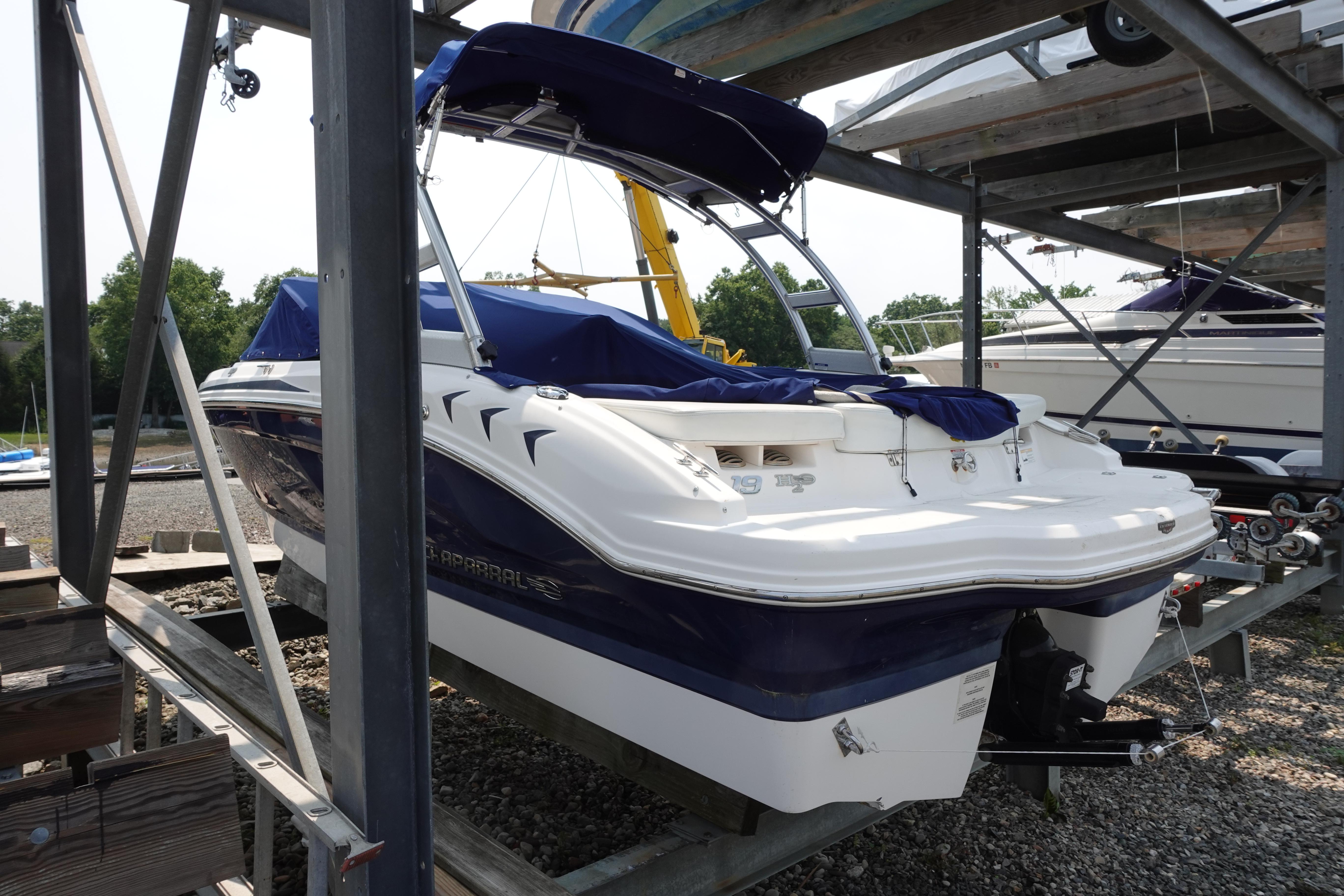 2013 Chaparral 19 Sport H2O boat on a storage rack, covered and ready for use.