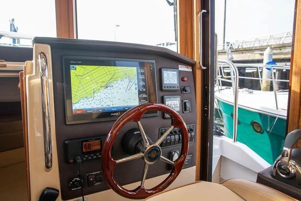 Helm of the Ranger Tugs R 31 LE with navigation system and wooden steering wheel.
