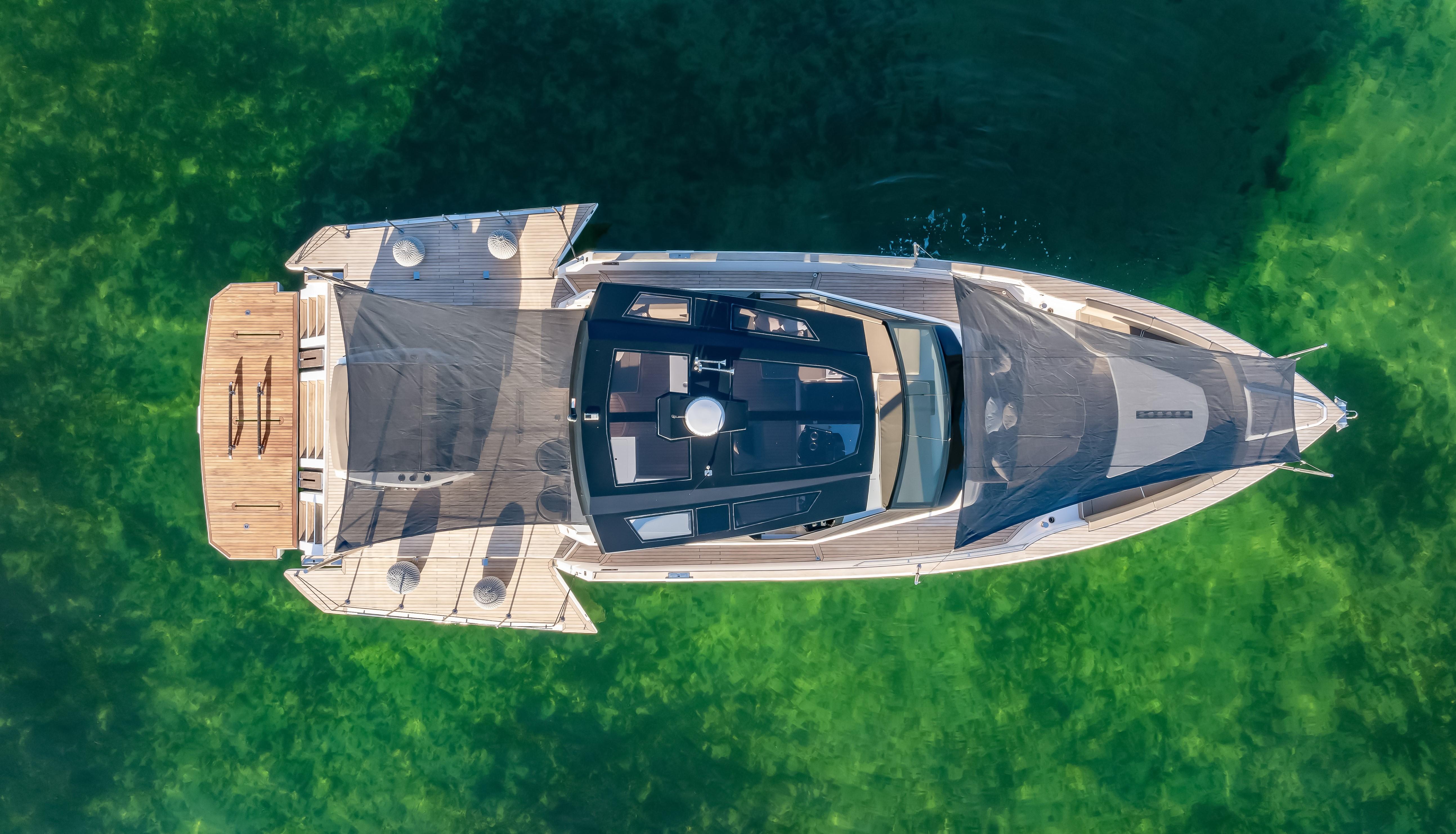 Aerial view of 2026 OKEAN 57 yacht on clear green water.