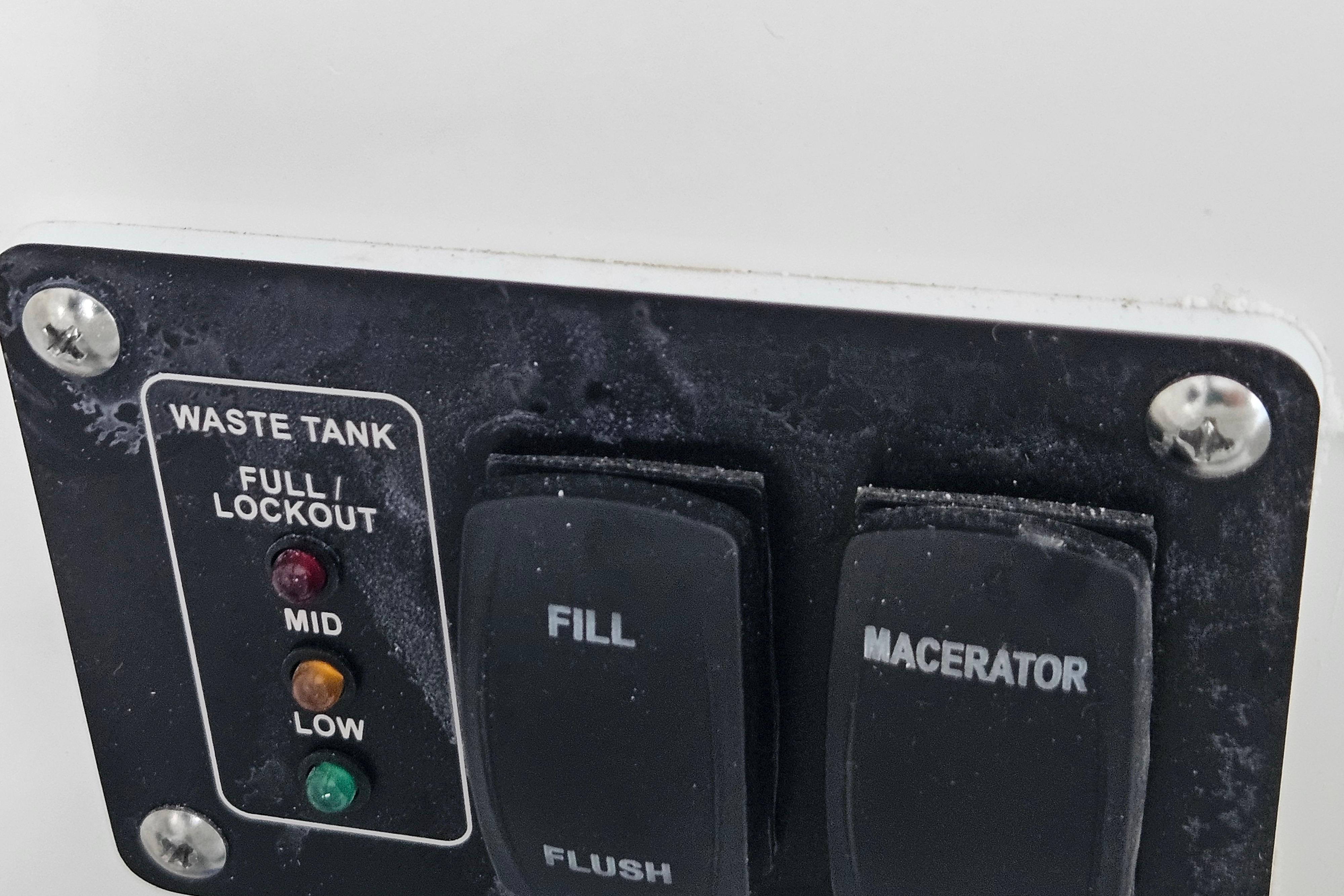 Control panel of a 2026 Monterey Elite 27 OB waste tank system with indicators and switches.