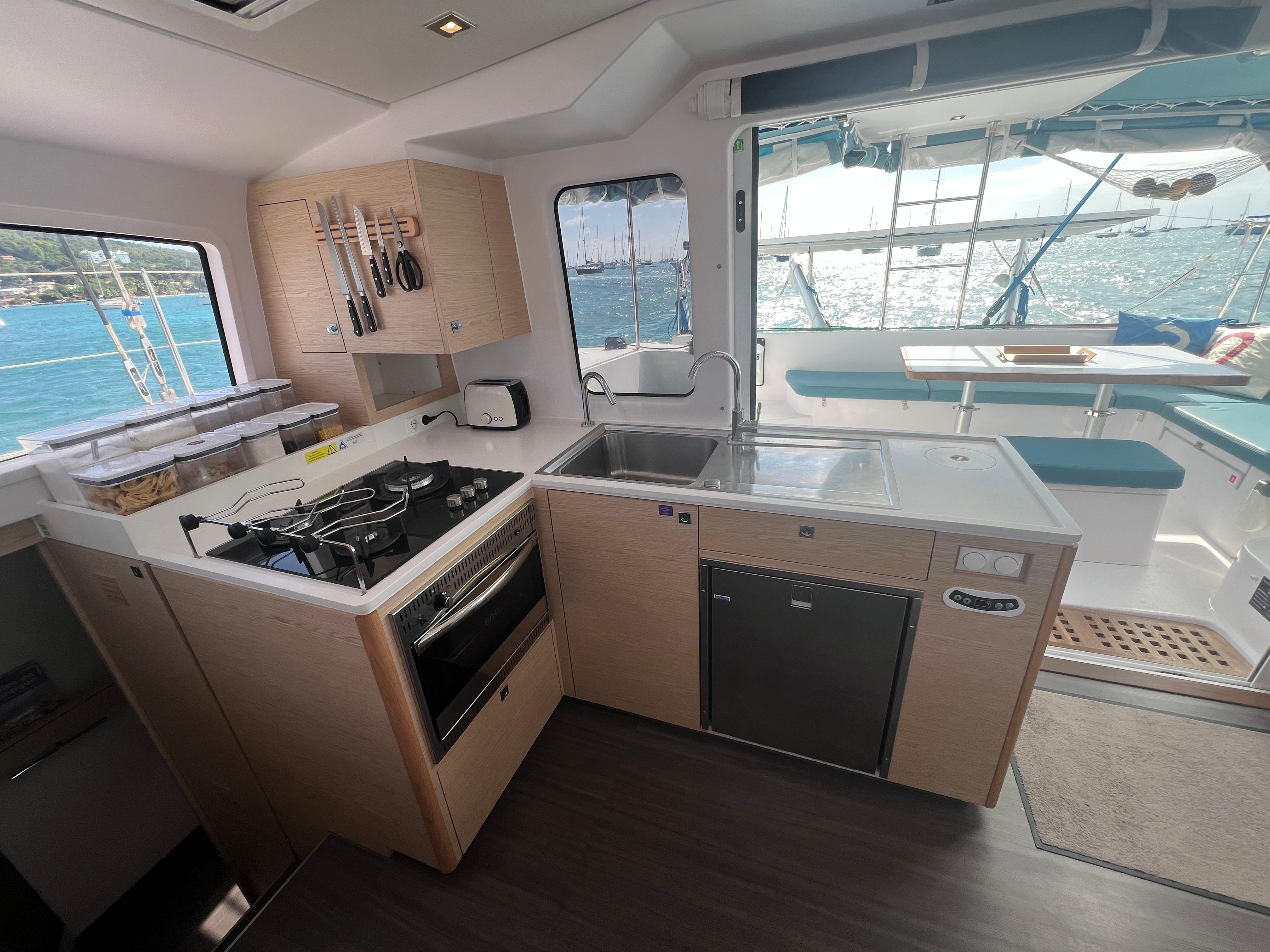 2024 Outremer 45 yacht interior with modern kitchen and ocean view.