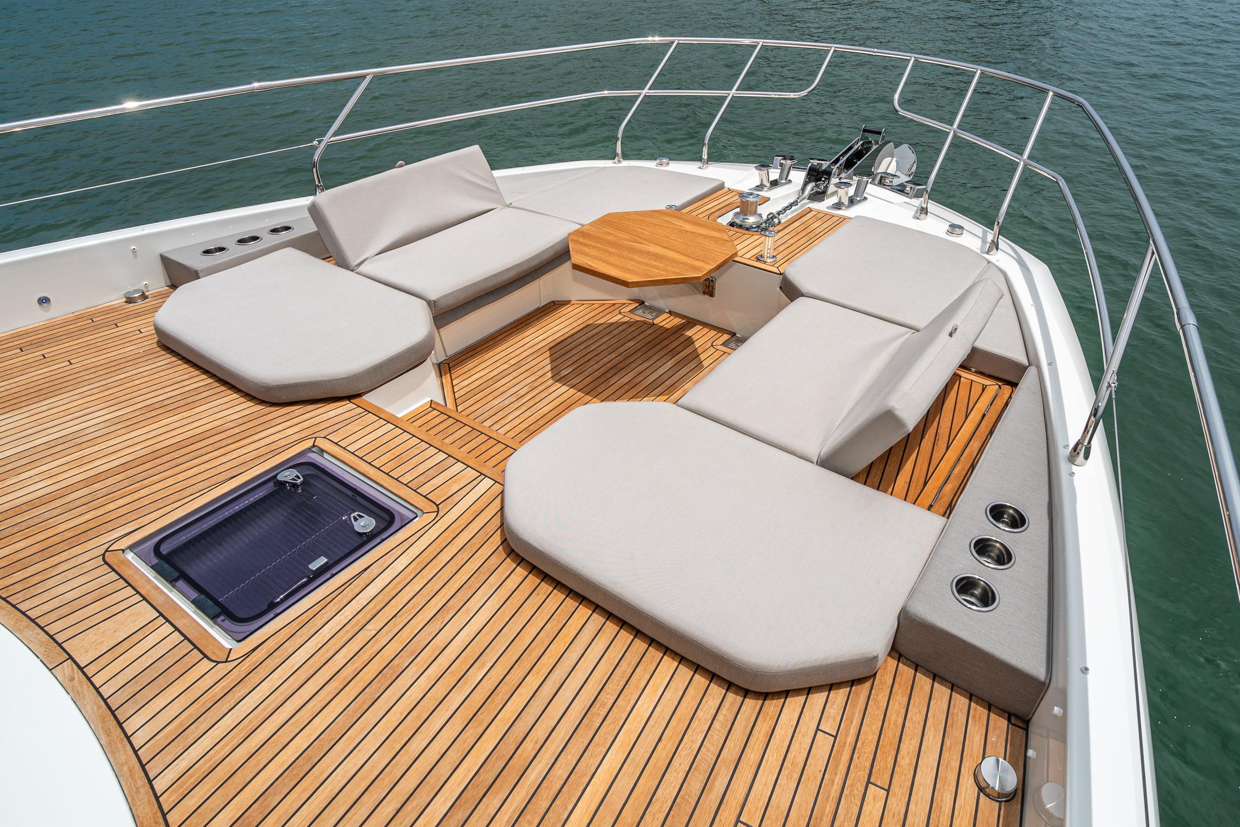 Luxurious 2024 Prestige X60 yacht deck with cushioned seating and wooden flooring.