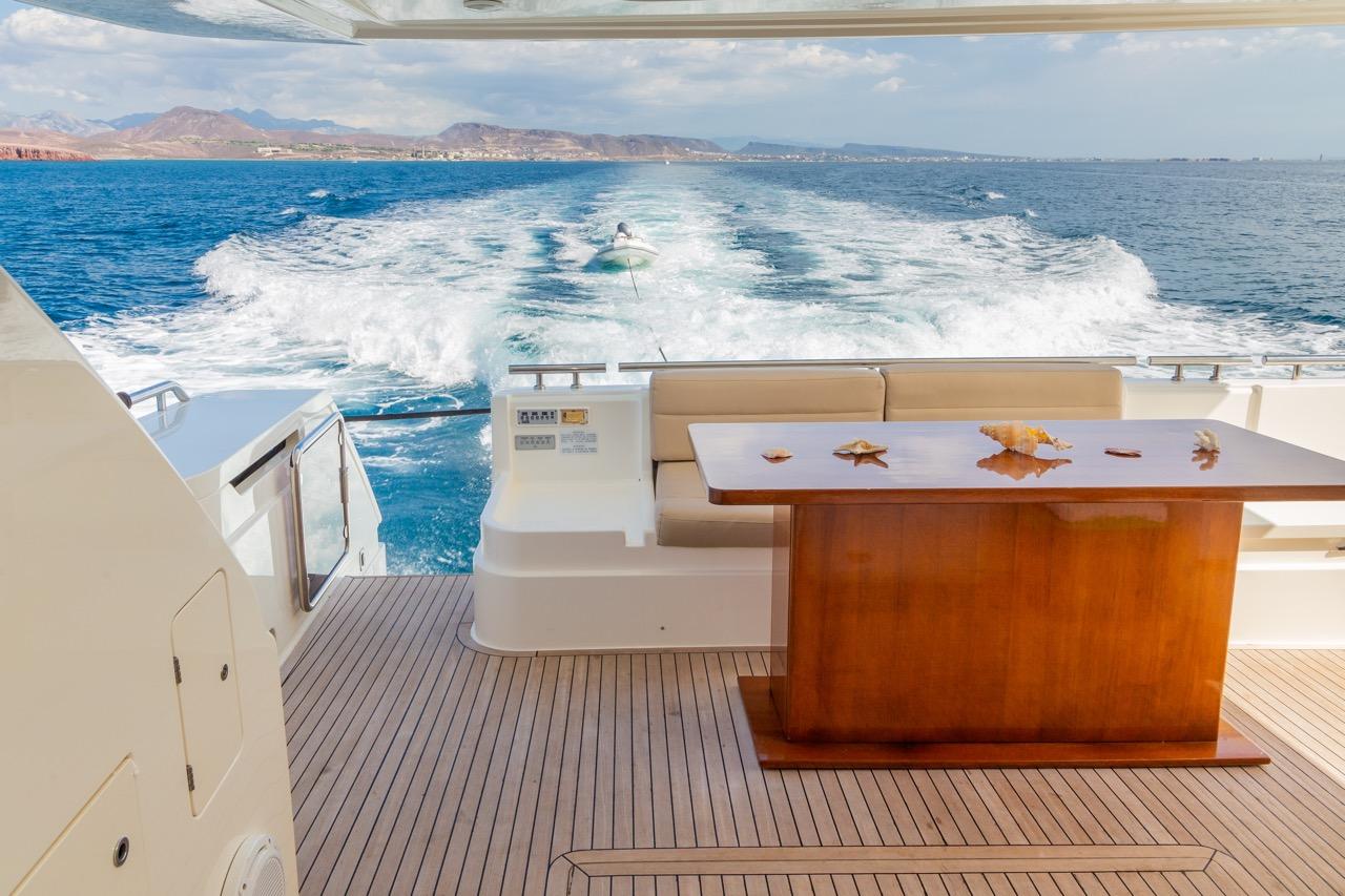 Ferretti Yachts 720 (2013) luxury yacht deck with ocean view and wooden table.