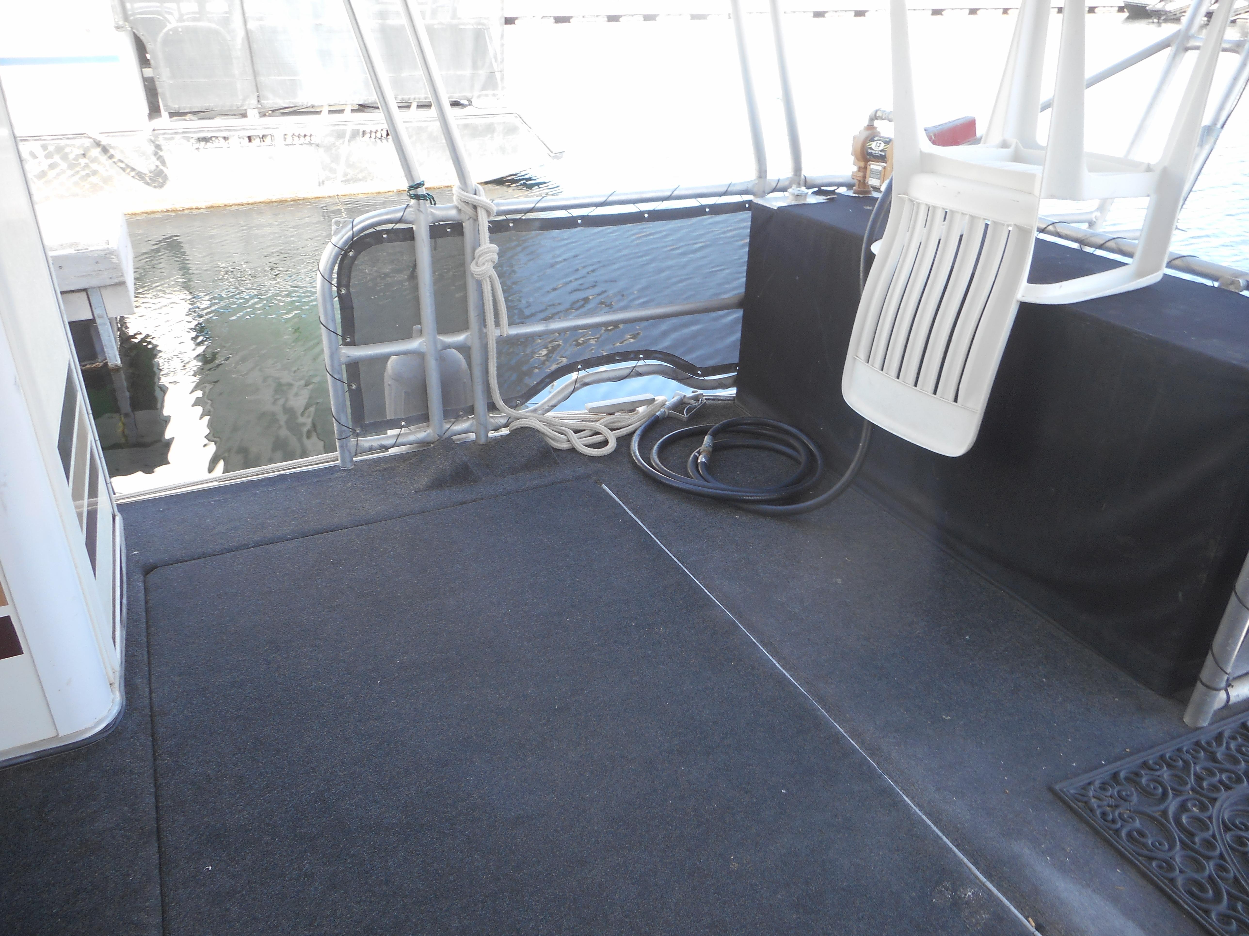 Houseboat deck area with seating, ropes, and water view. Stardust Cruisers Pure Enchantment 2000.