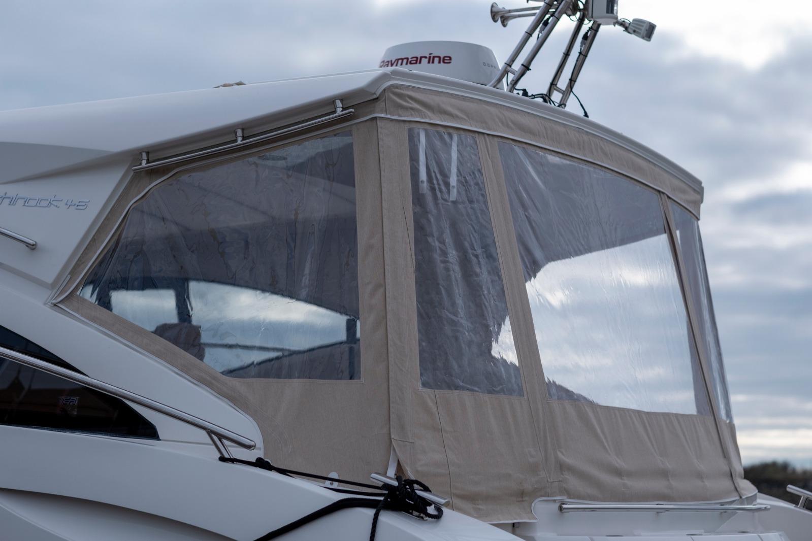 2019 Windy 46 Chinook yacht with enclosed cockpit under cloudy sky.