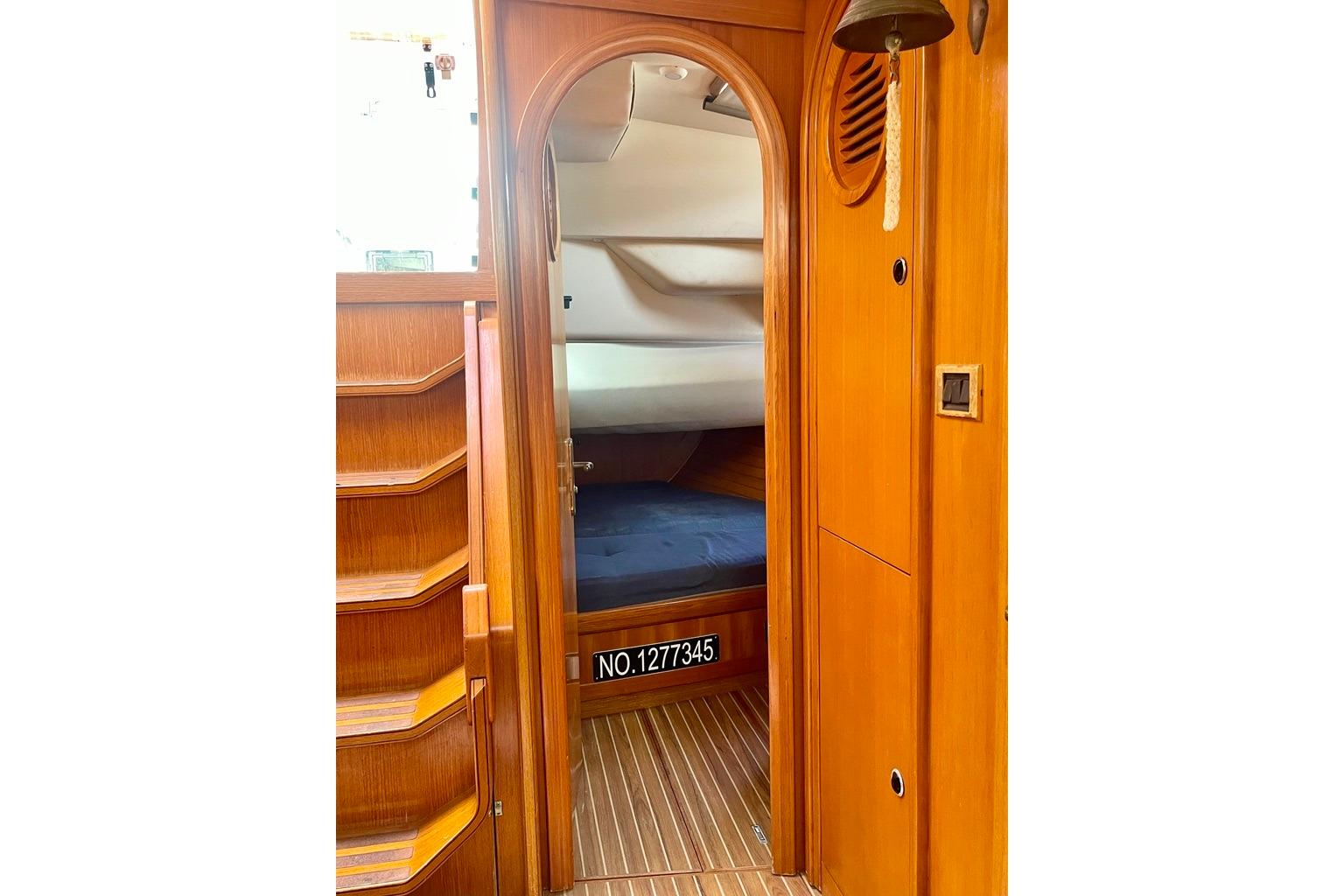 Interior of 1997 Feeling 546 yacht, featuring wooden cabin and cozy sleeping area.