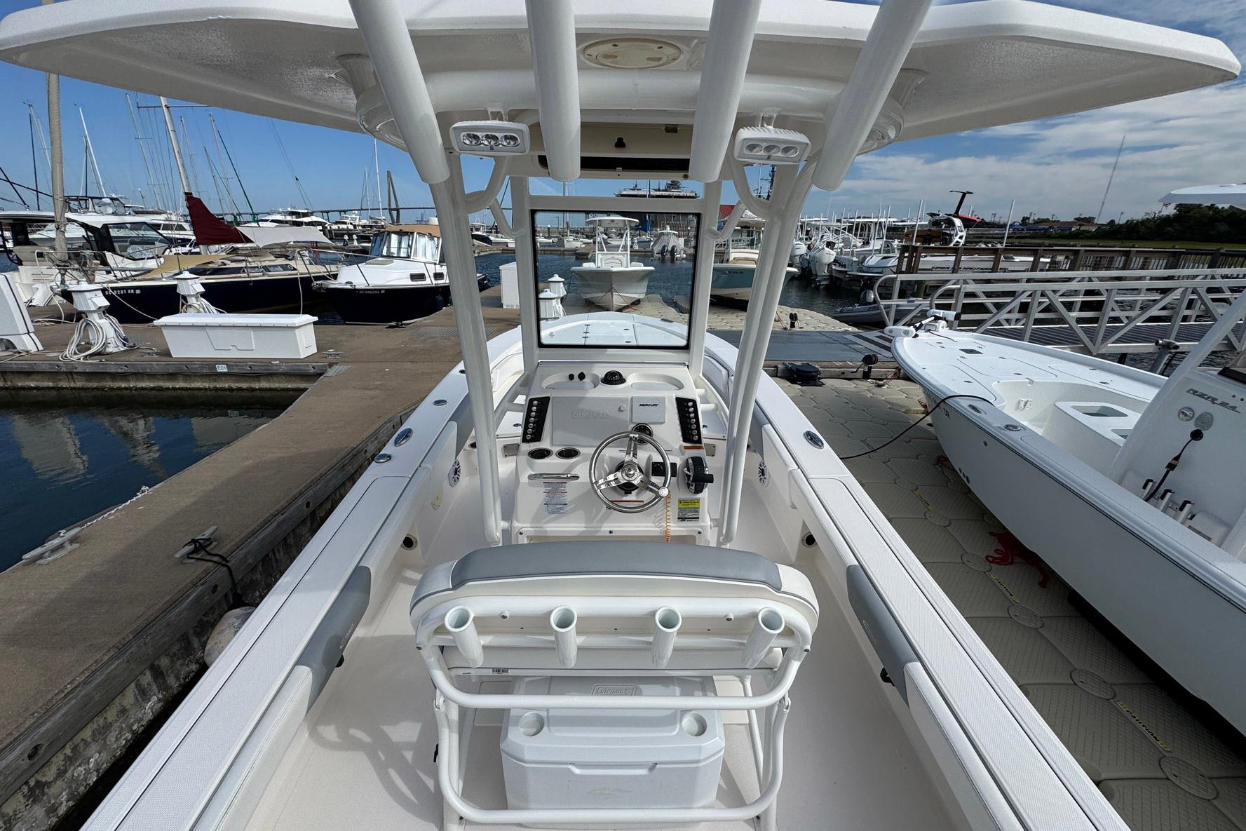 2021 Robalo 246 Cayman boat docked at marina, showcasing helm and seating area.