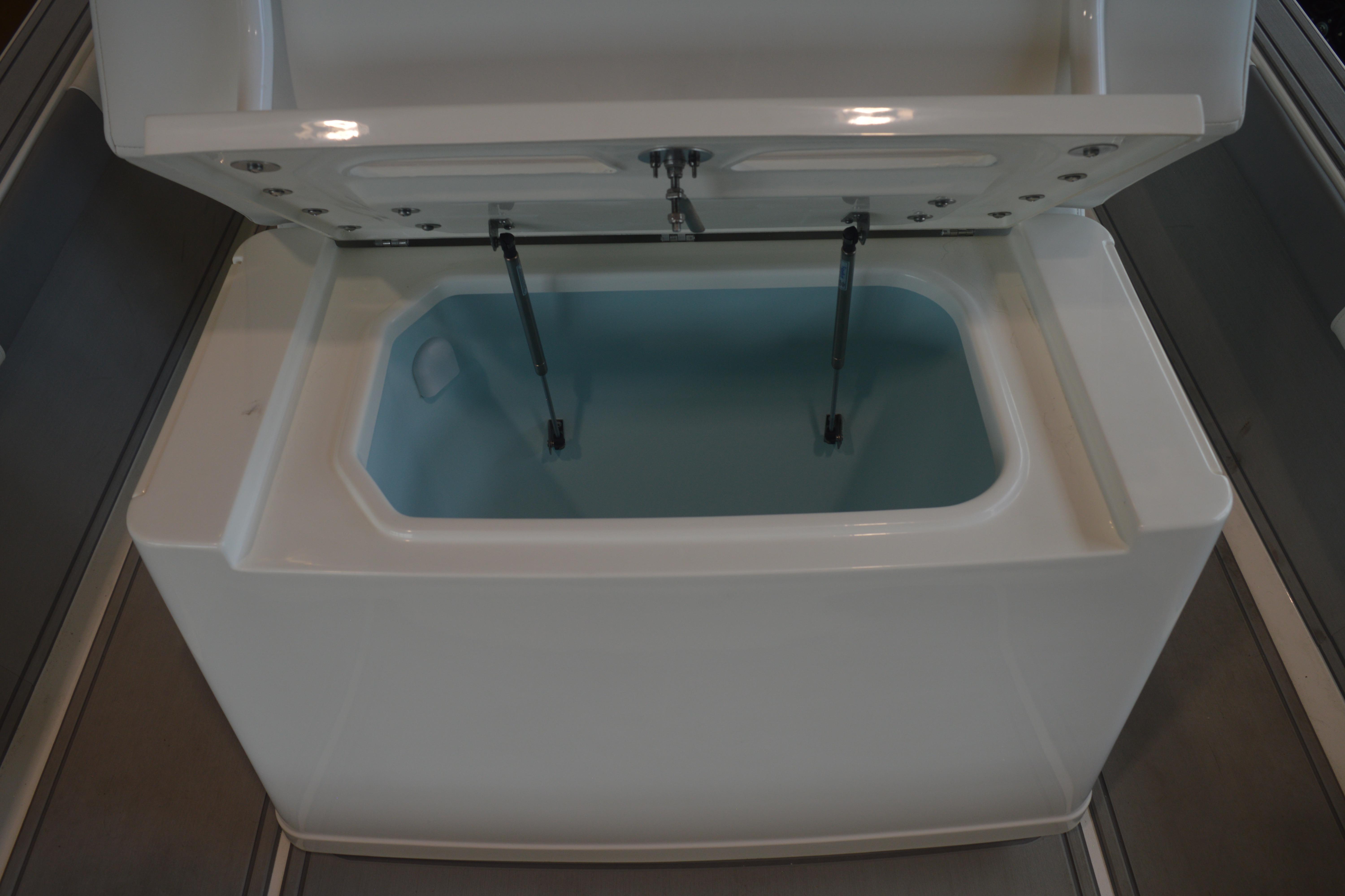 Open storage compartment on 2026 Mako 24 APEX boat, showcasing interior design.