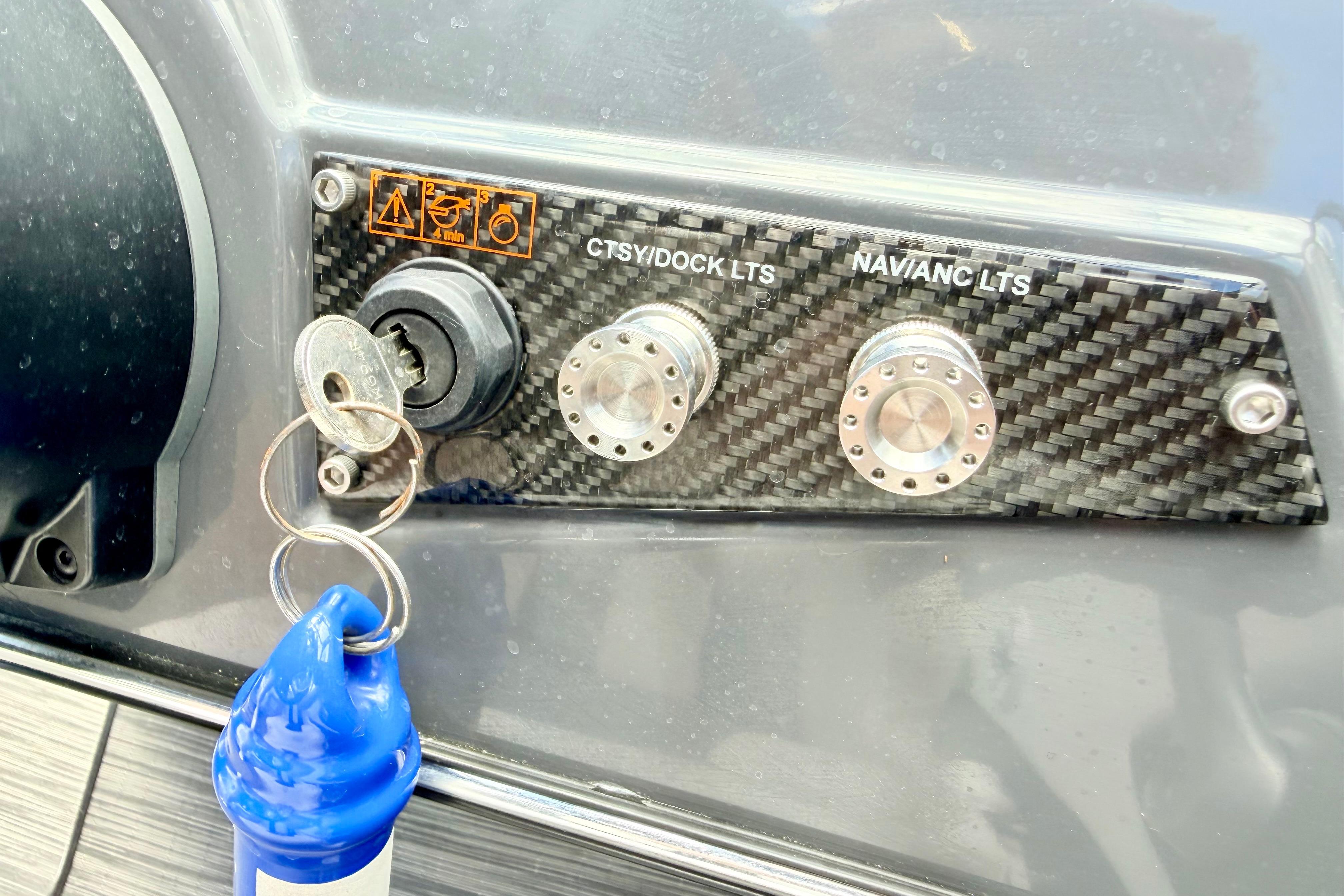 Control panel of a 2018 Glastron GT 185 boat with ignition key and switches.