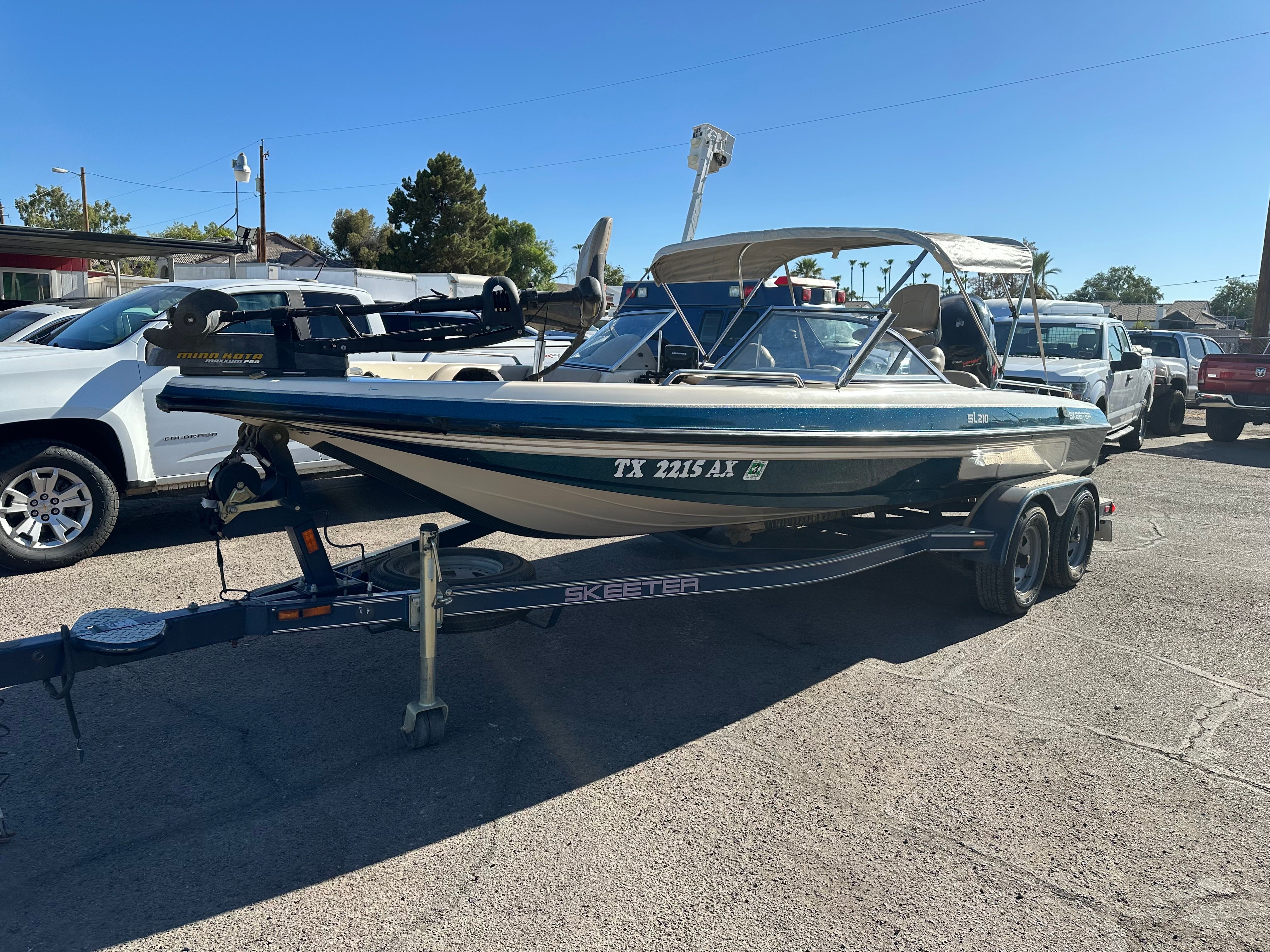 A 2008 Skeeter SL 210 boat on a trailer in a parking lot.