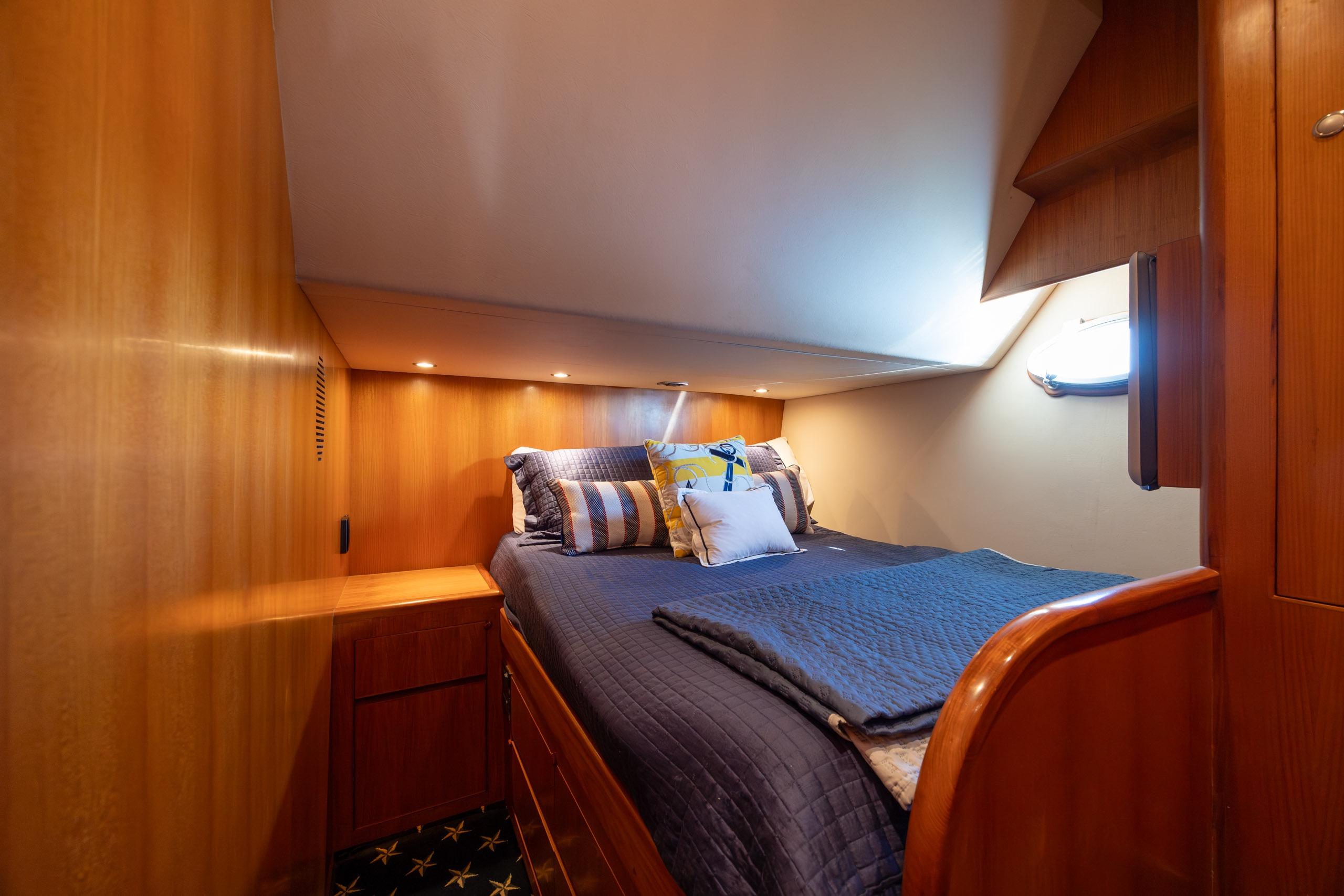 Luxurious cabin interior of 2005 Ocean Alexander 52 Sedan yacht with cozy bedding.