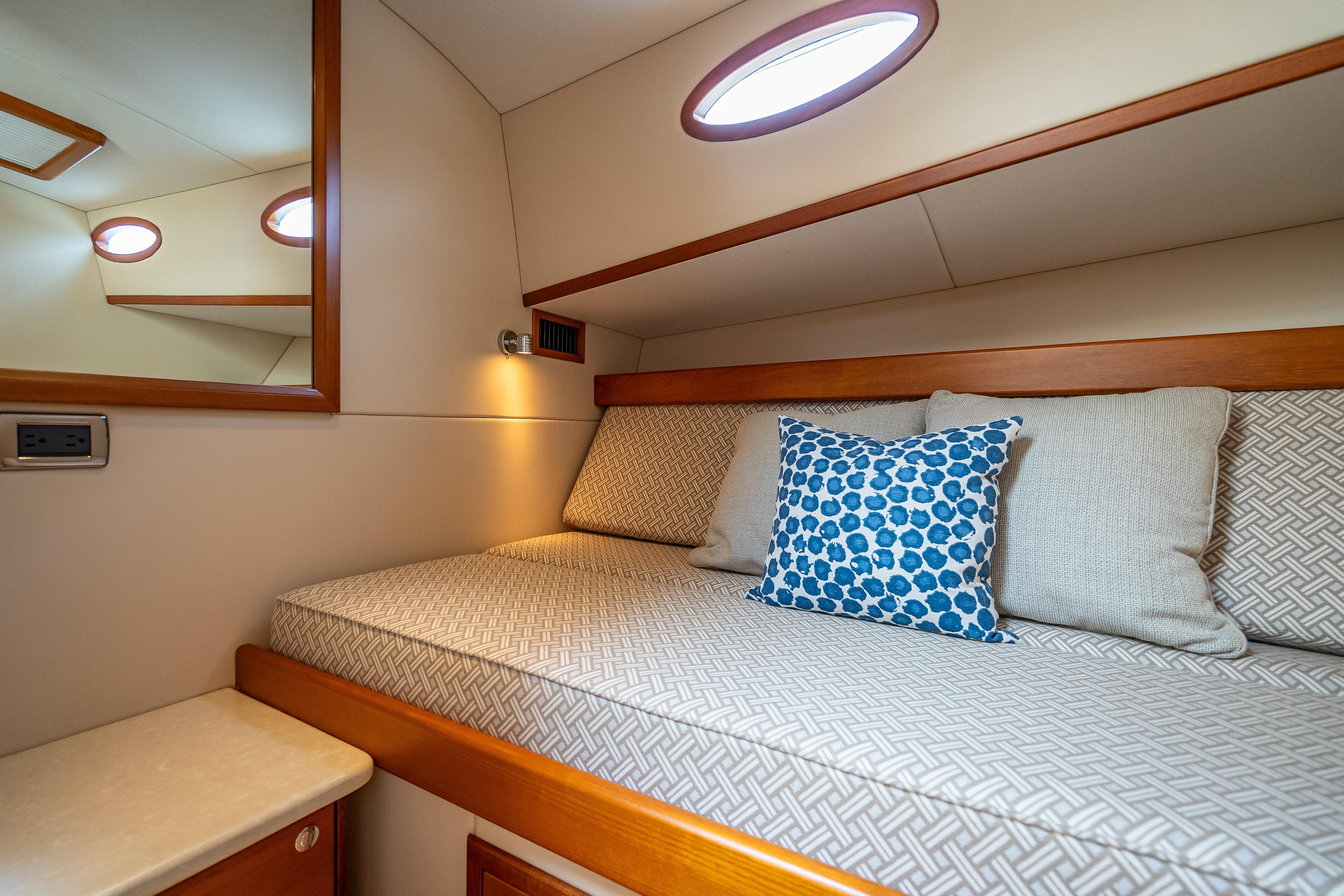 Luxurious cabin interior of 2018 Palm Beach Motor Yachts PB50 with cozy bedding and cushions.