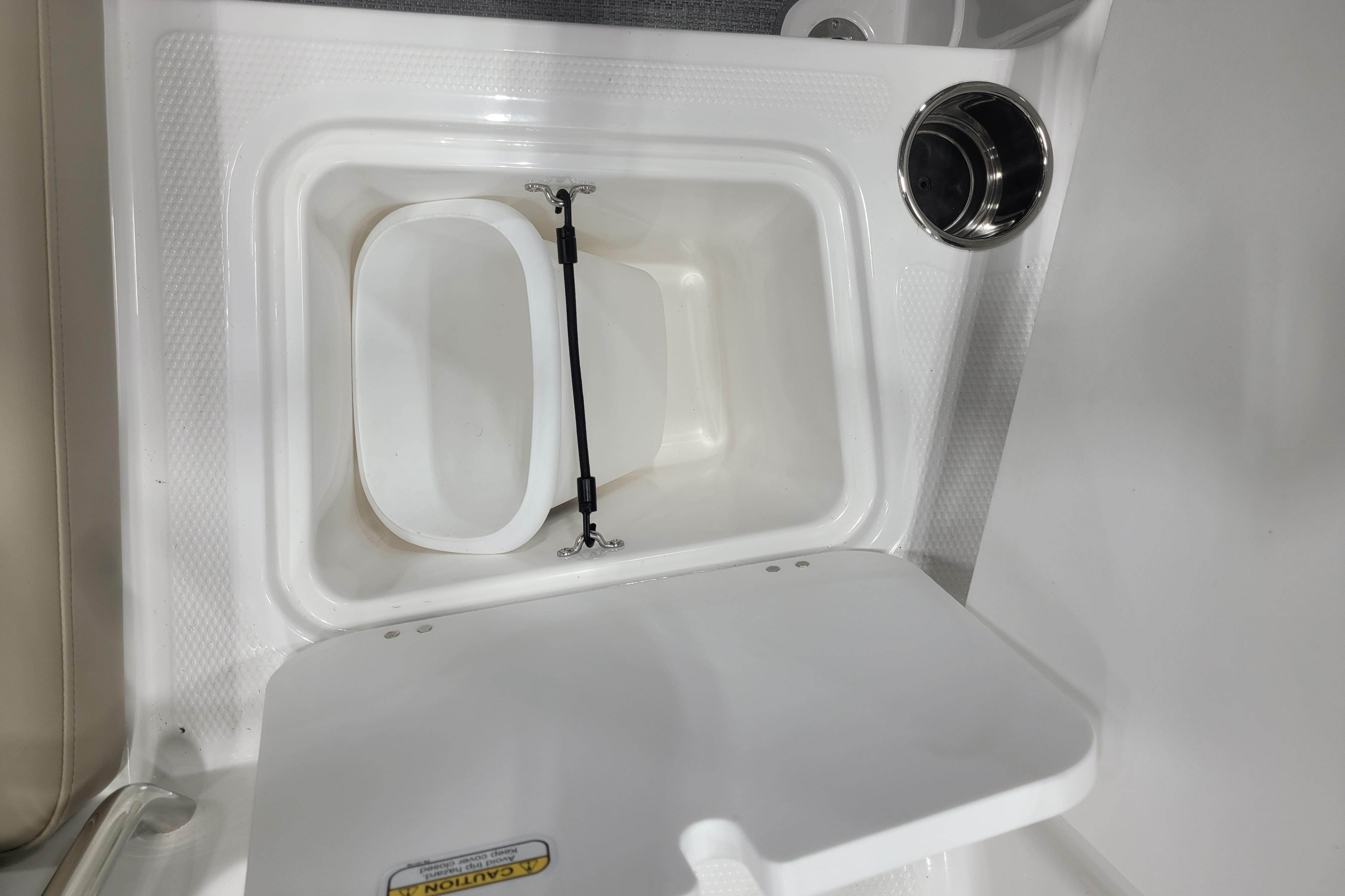 Storage compartment in 2026 Tahoe 2150 boat, featuring a secure latch and cup holder.
