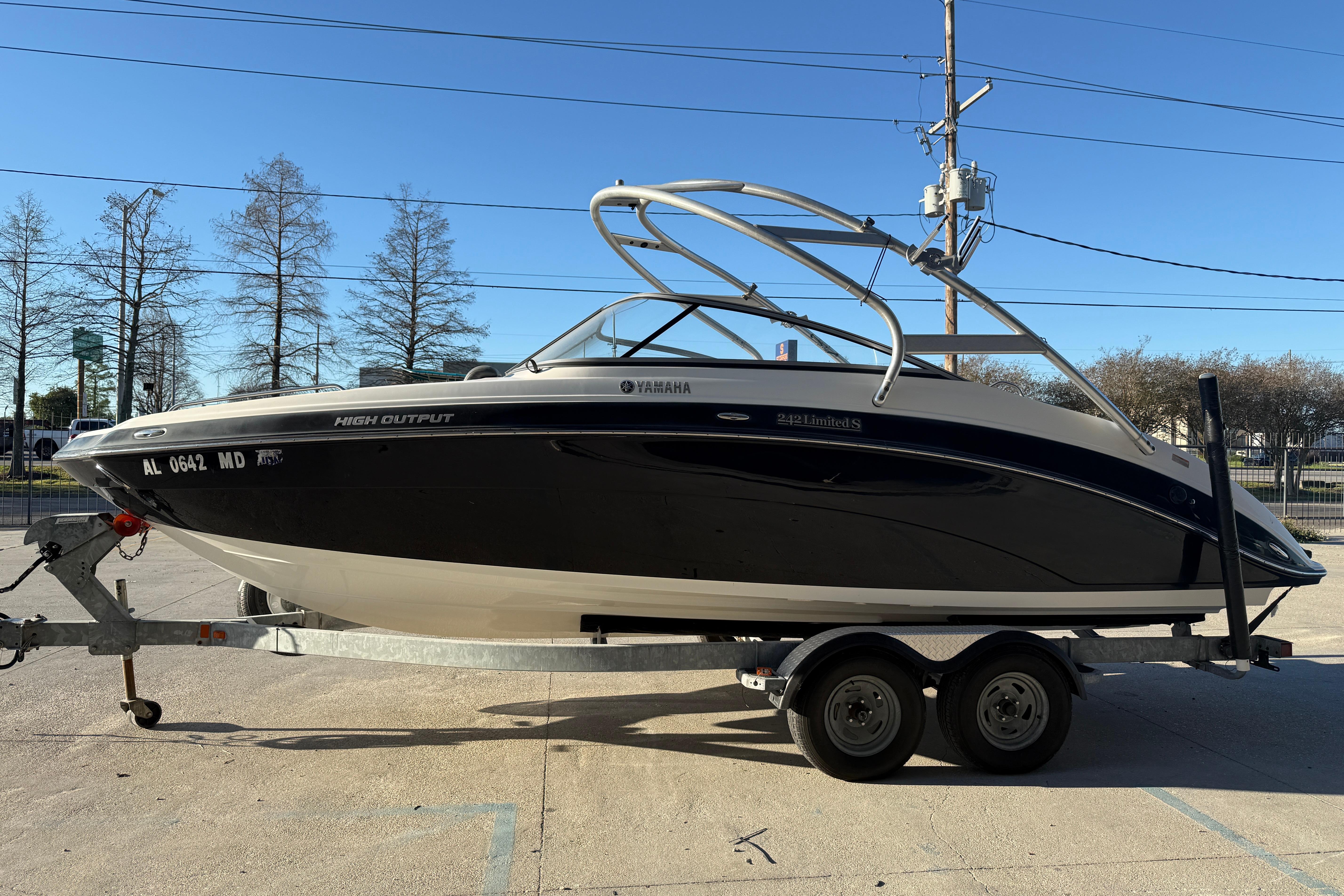 2011 Yamaha Boats 242 Limited S on trailer, black and white design, parked outdoors.