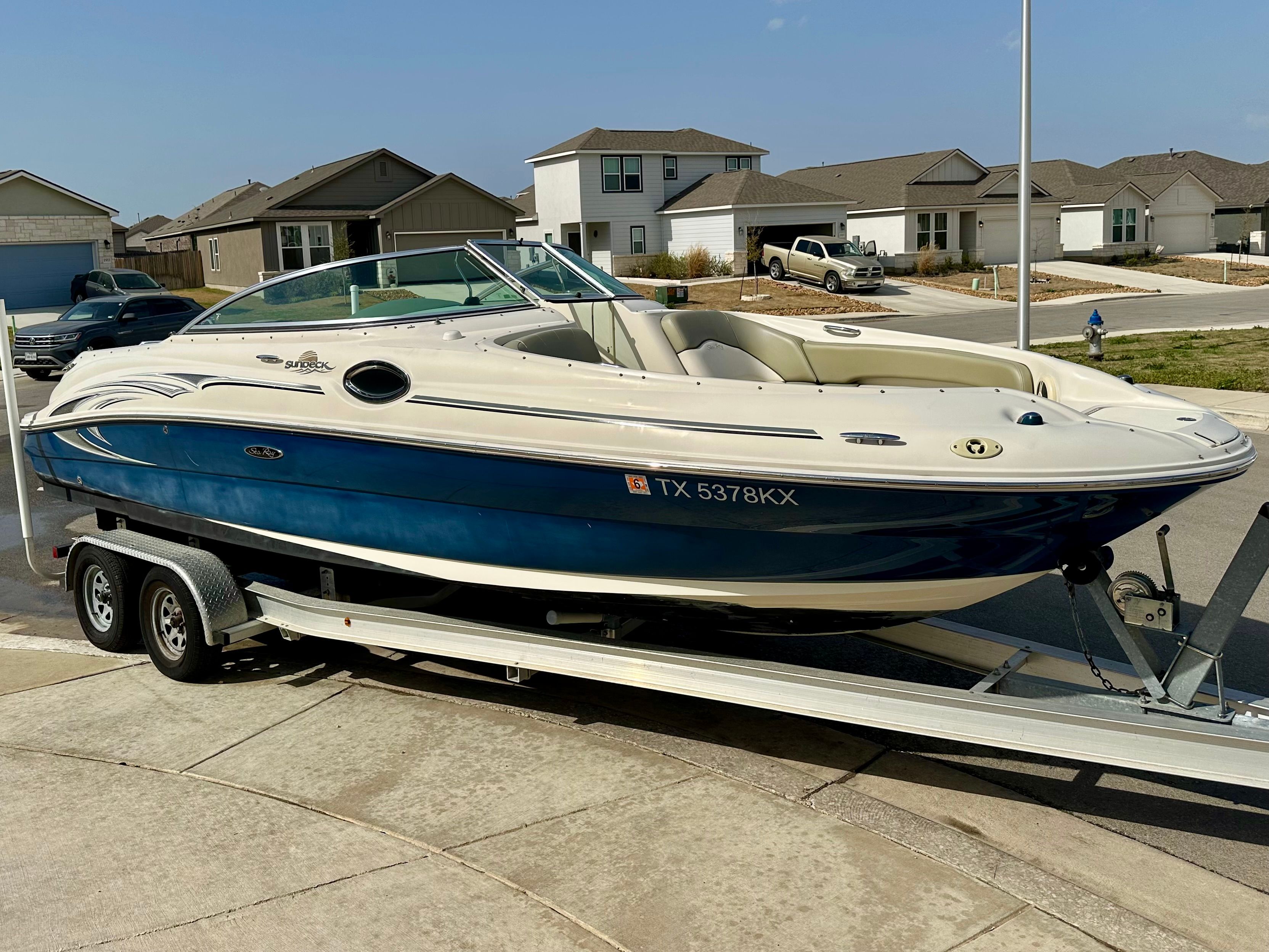 2006 Sea Ray 240 Sundeck boat on trailer in residential area.