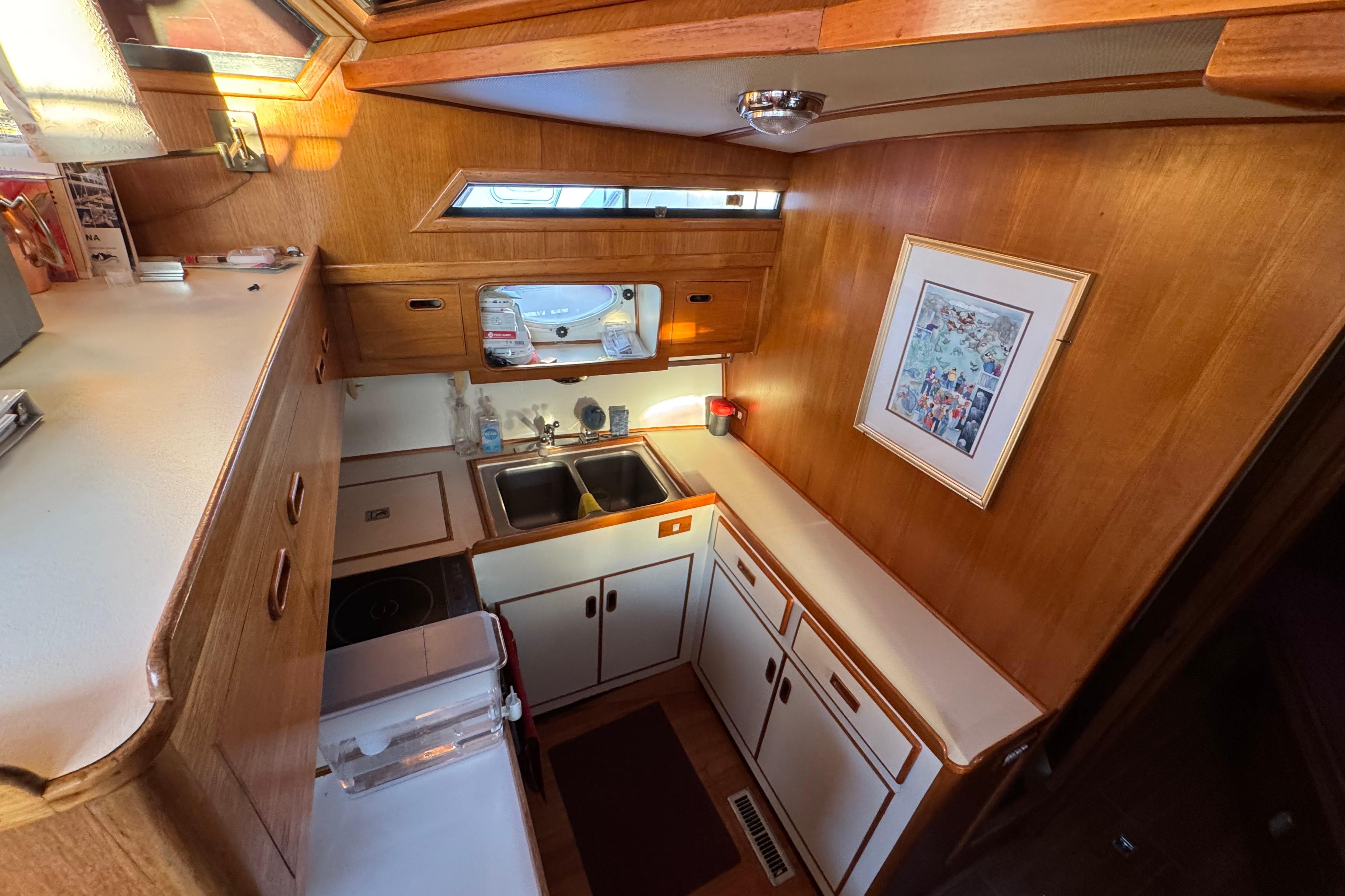 Cozy 1987 President 37 yacht kitchen with wood cabinetry and dual sinks.