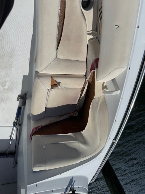 The boat seat upholstery is heavily damaged and torn.