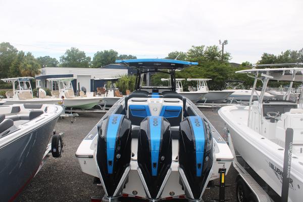 2024 Fountain 34 SC boat with triple engines, displayed in a marina setting.
