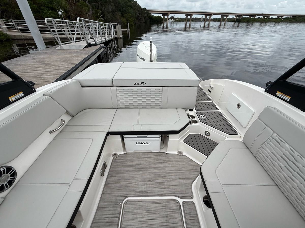 The image shows the cockpit of a 2024 Sea Ray SPX 230 Outboard with gray upholstery.