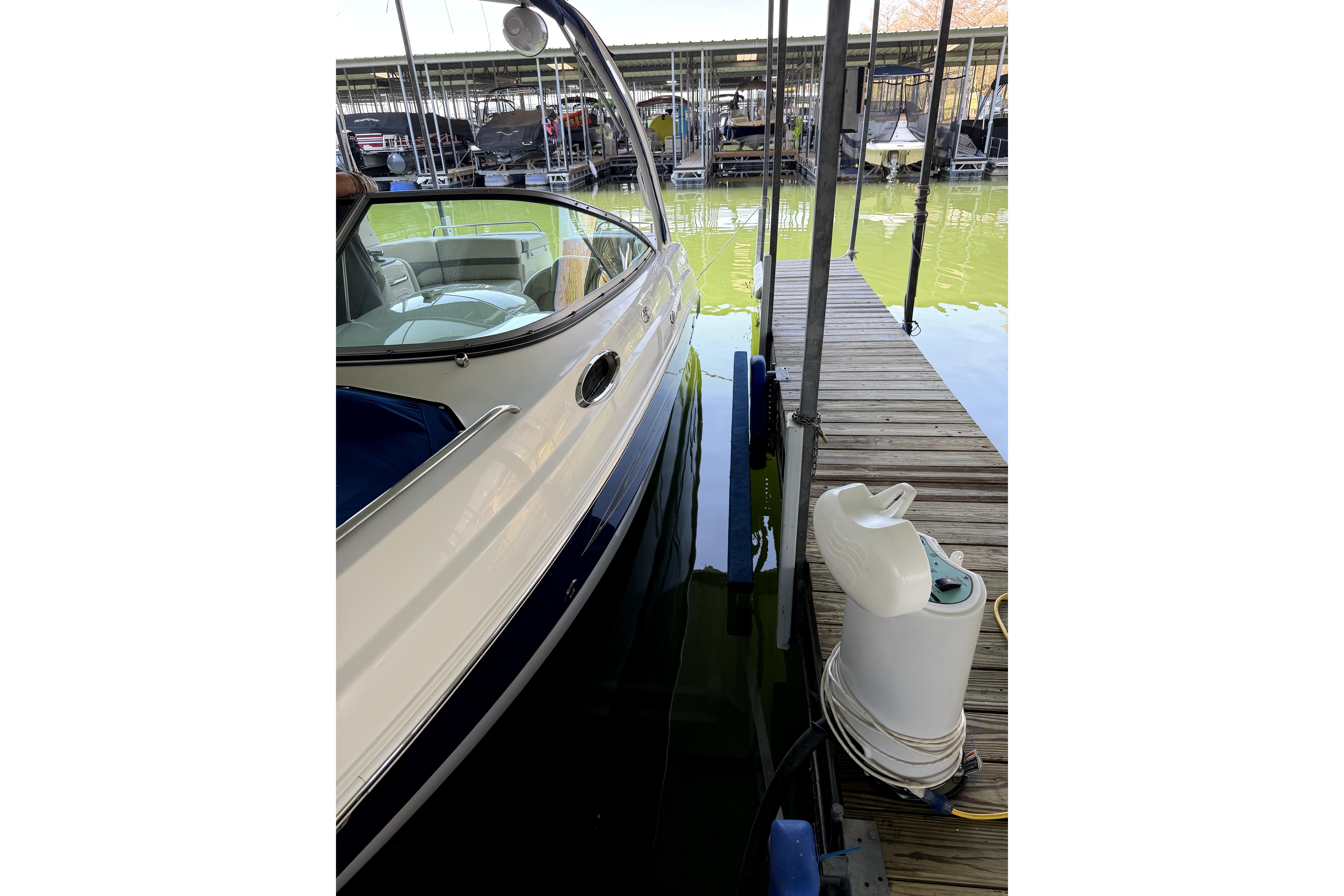 2005 Chaparral 256 SSi boat docked at marina with green water.