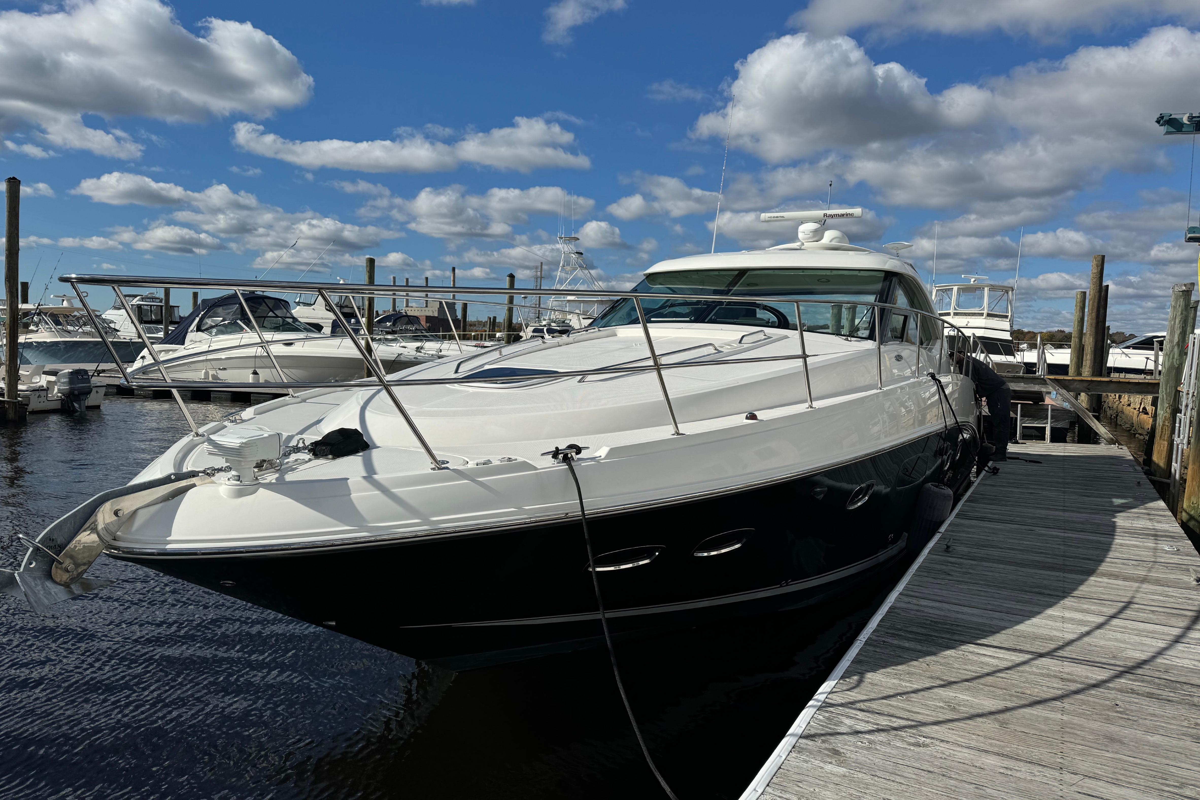 2011 Sea Ray 470 Sundancer yacht docked at marina under blue sky.