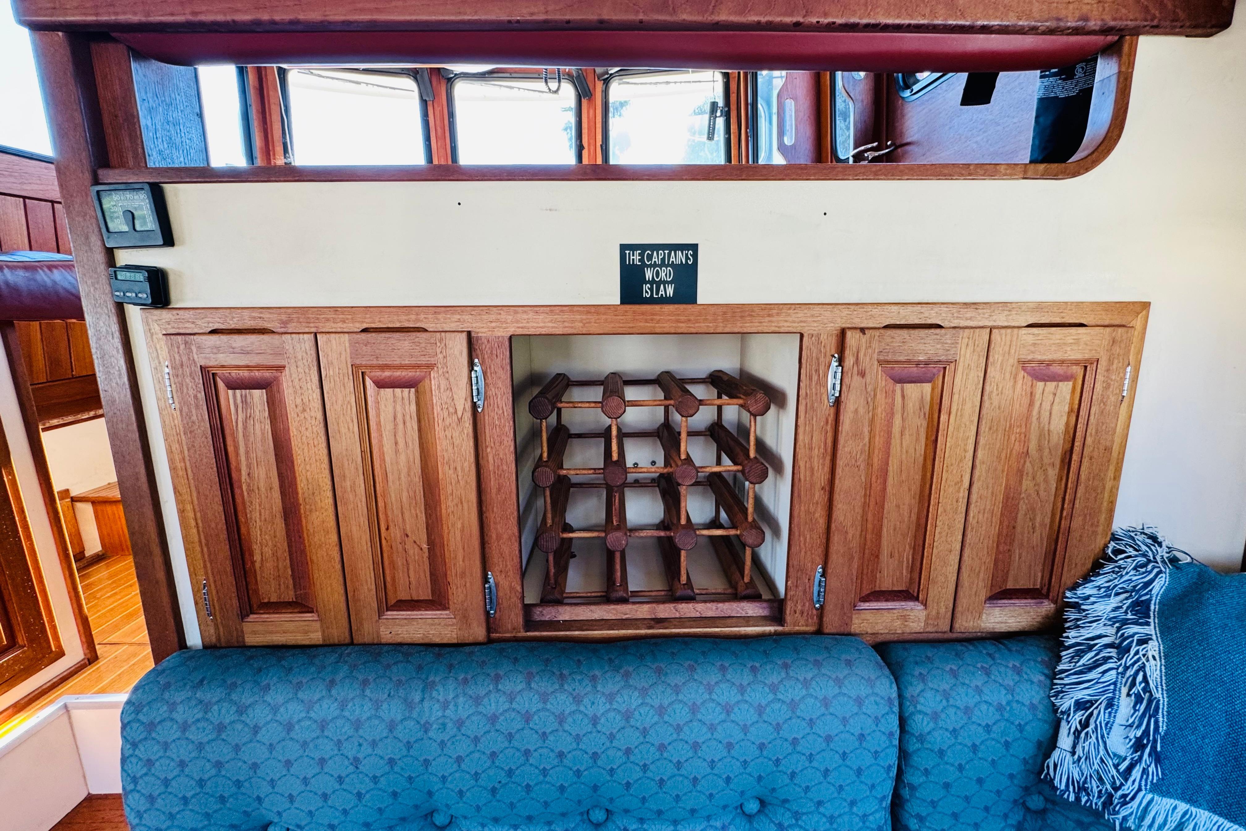 Interior of a 1996 Nordic Tug 32 with wooden cabinets and wine rack.