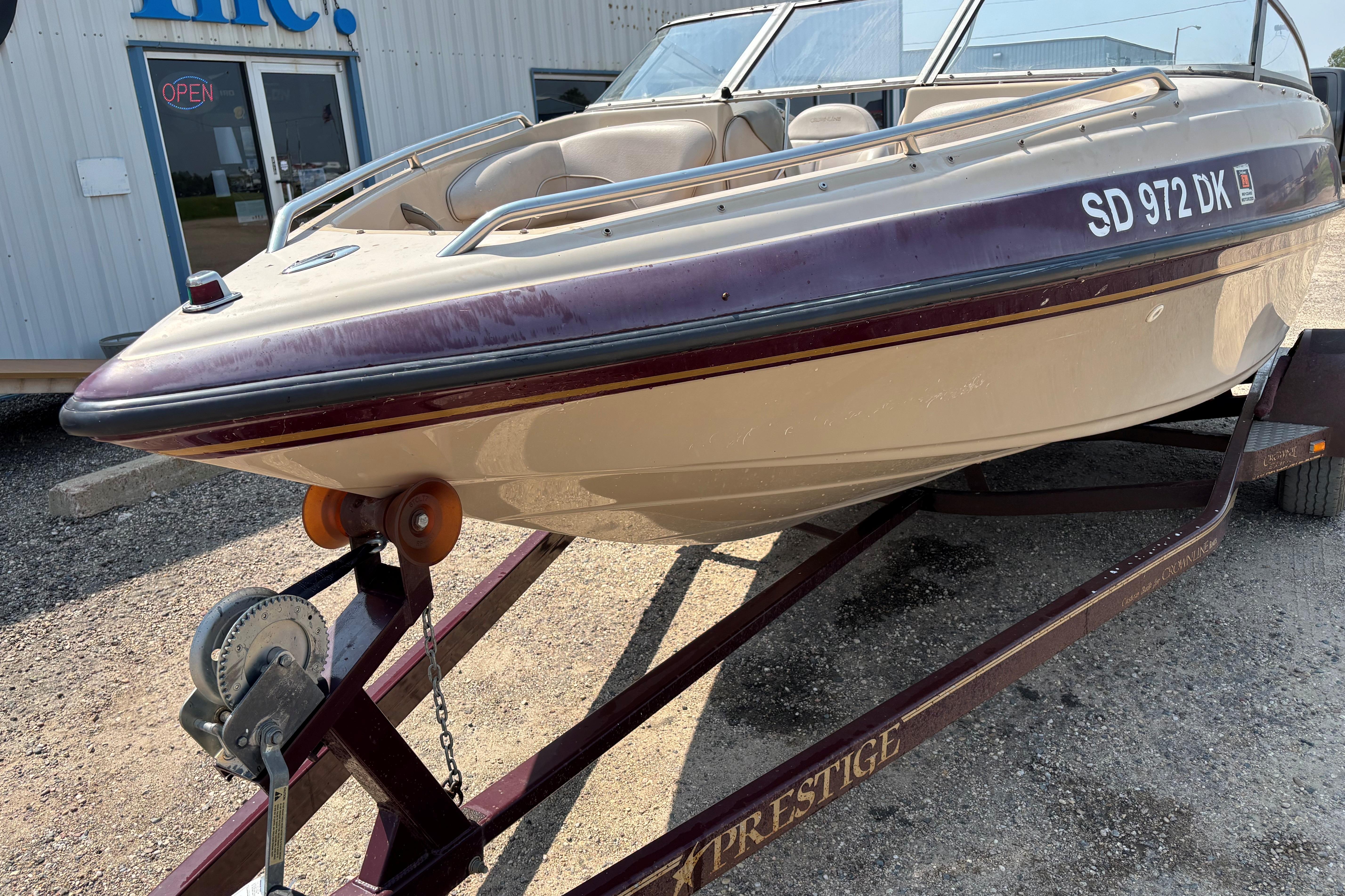 2001 Crownline 18' boat on trailer, parked outside a building.