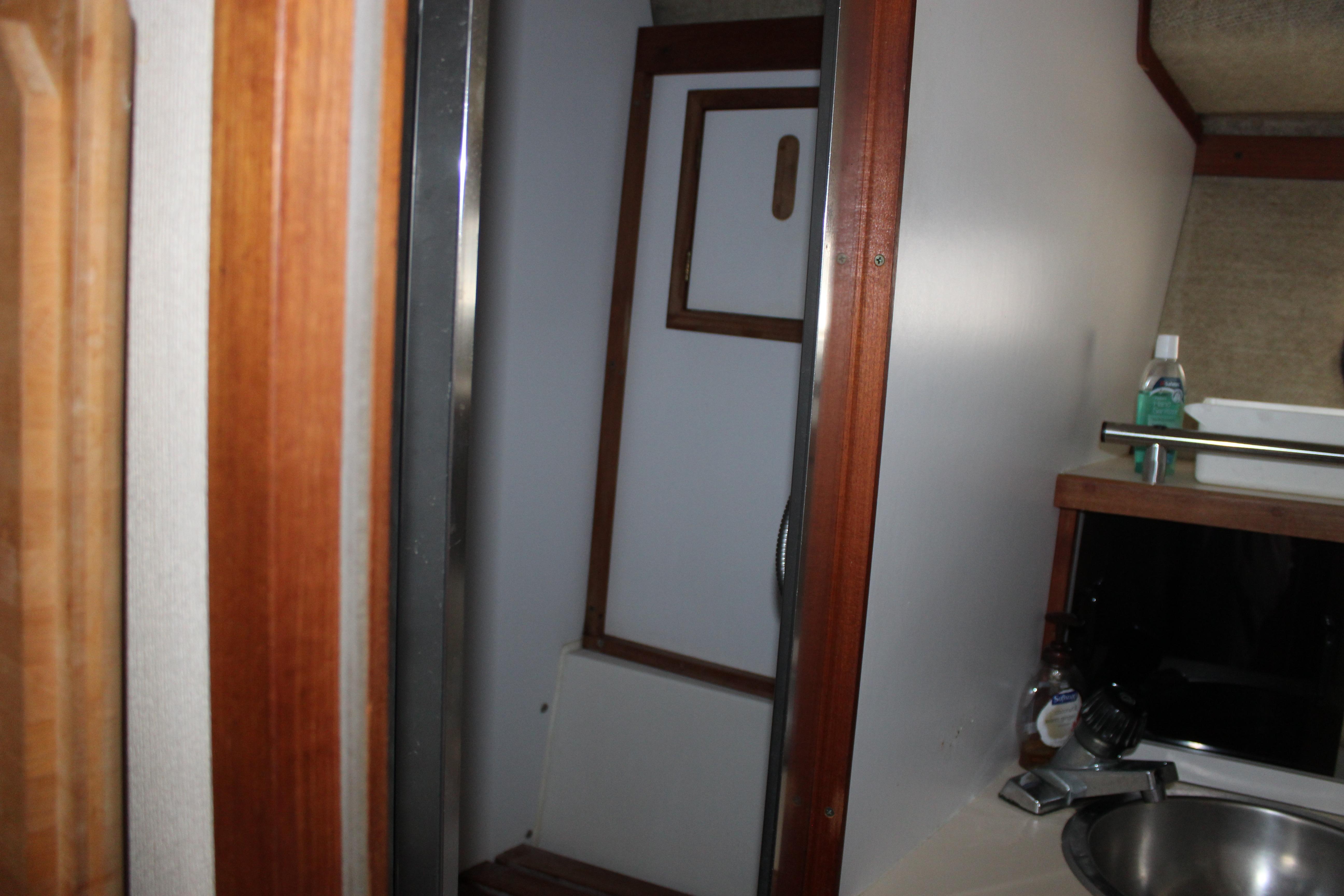 Interior of 1985 Carver 32 Convertible boat, featuring a compact bathroom area.