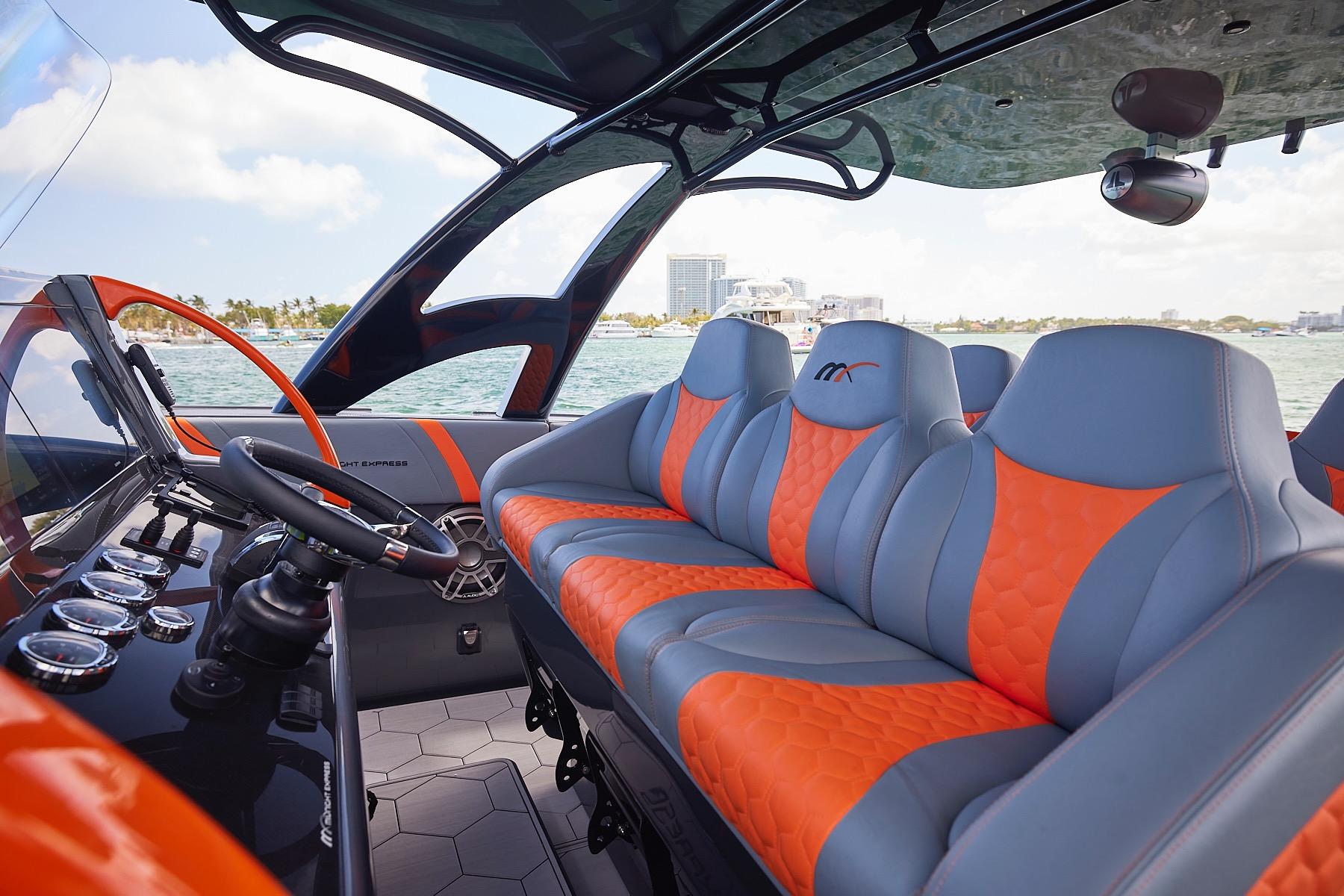 Luxurious interior of 2022 Midnight Express 43 Open boat with orange and gray seating.